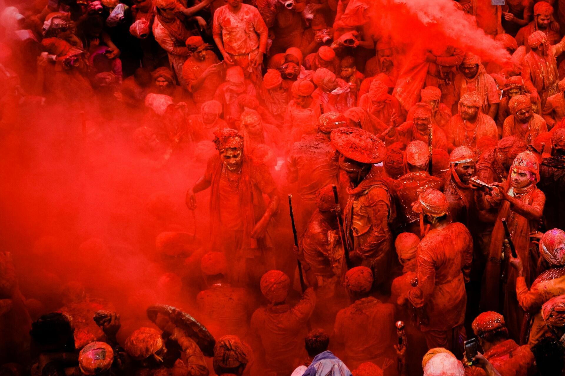 Red powder being throw during the Holi festival.