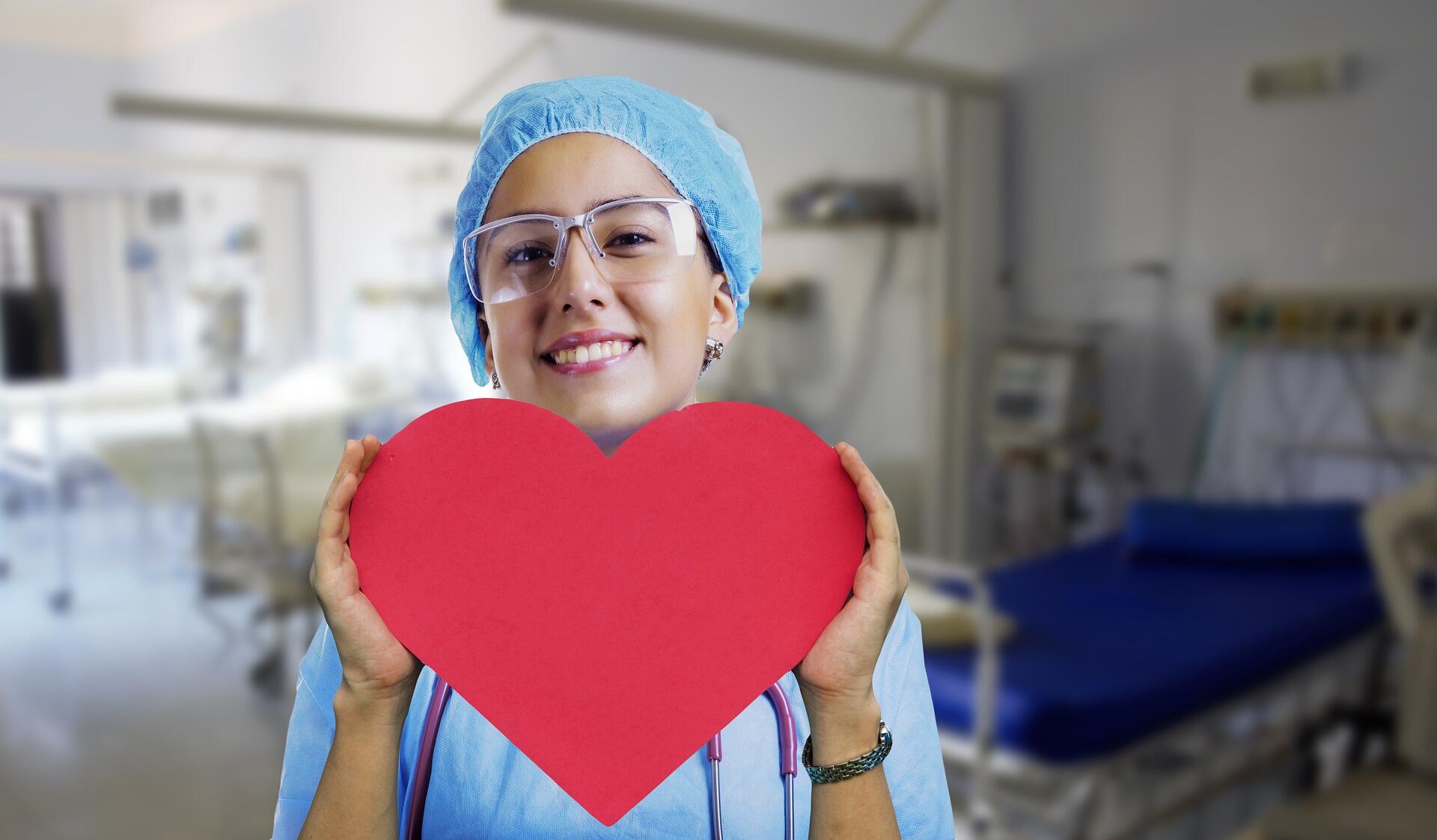A nurse carrying a red paper heart.