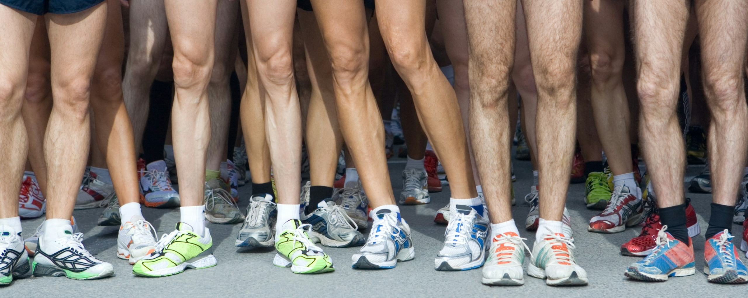 A group of people showing off their running shoes.