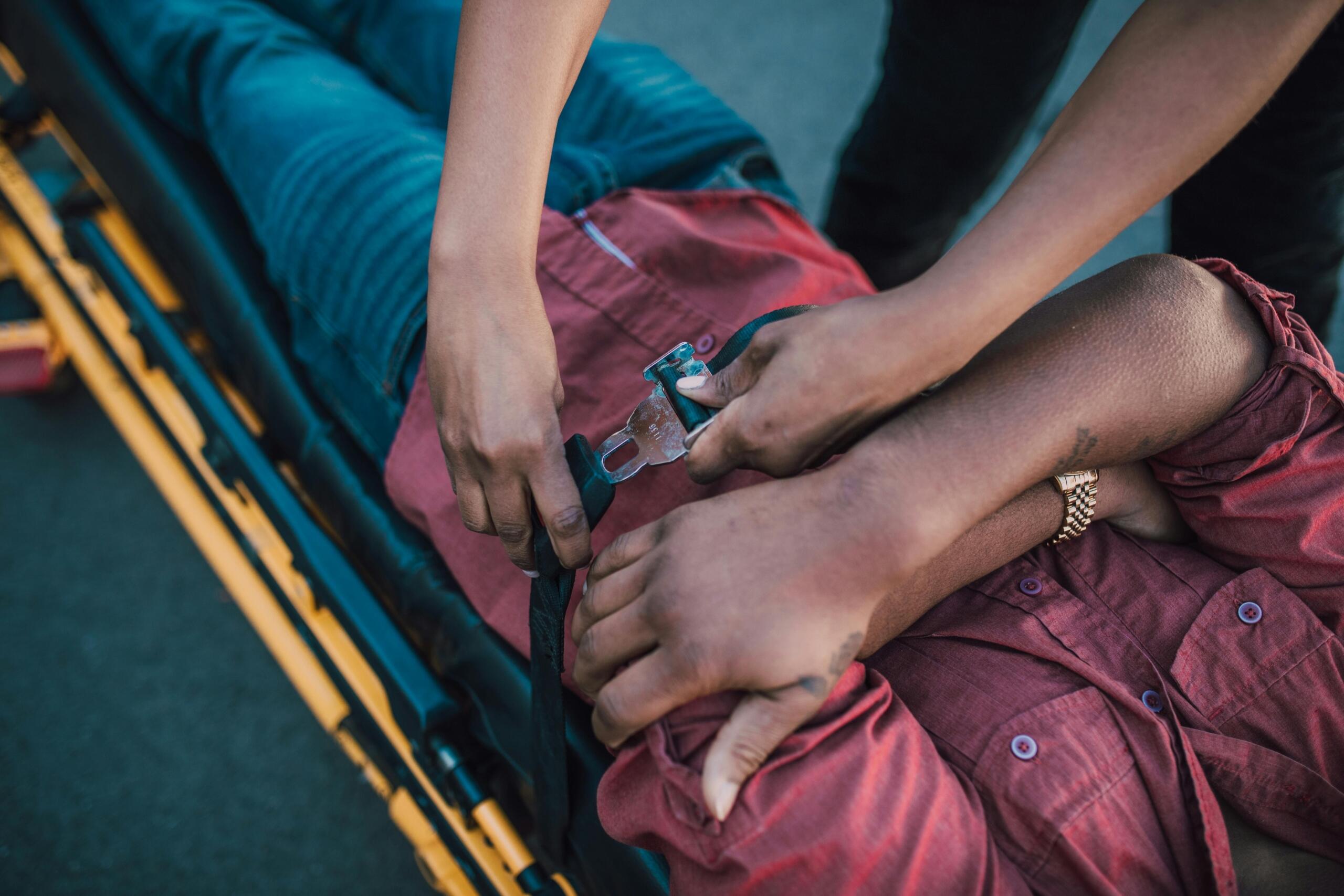 A man lying on a stretcher receiving first aid from emergency responders.
