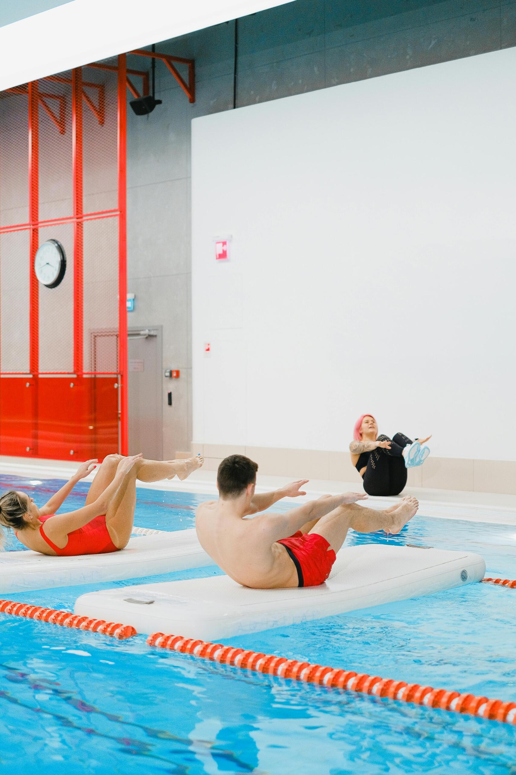 Group of adults participating in water-based exercise in a swimming pool.