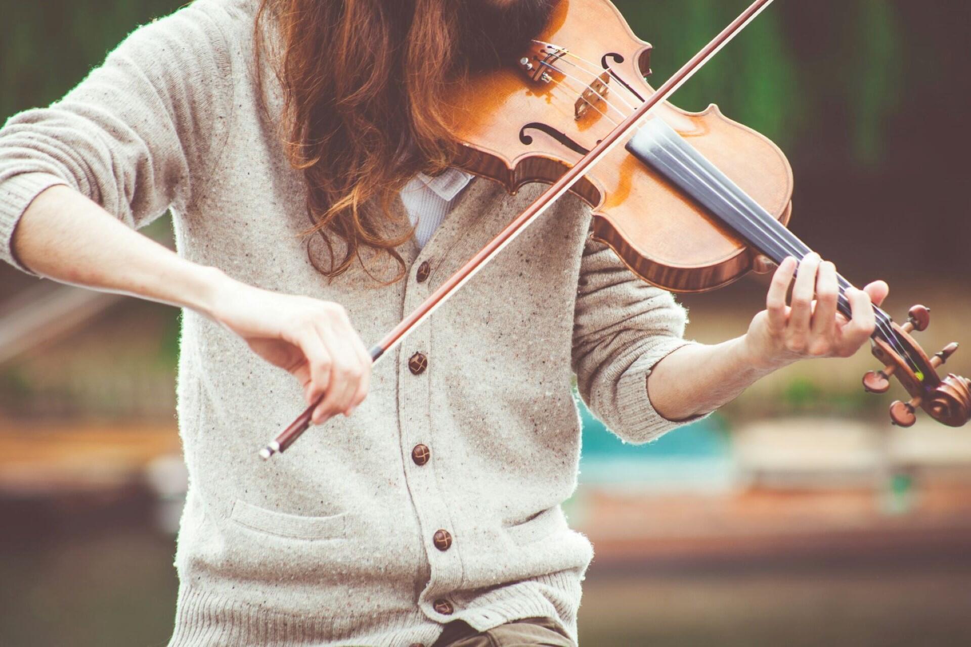 A violinist performing in a cardigan.