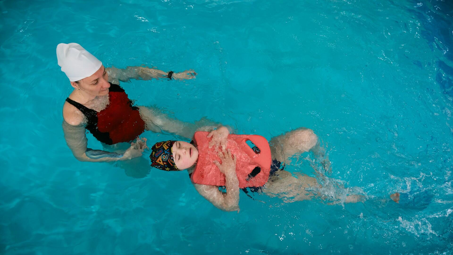 An instructor and student during a swimming lesson.