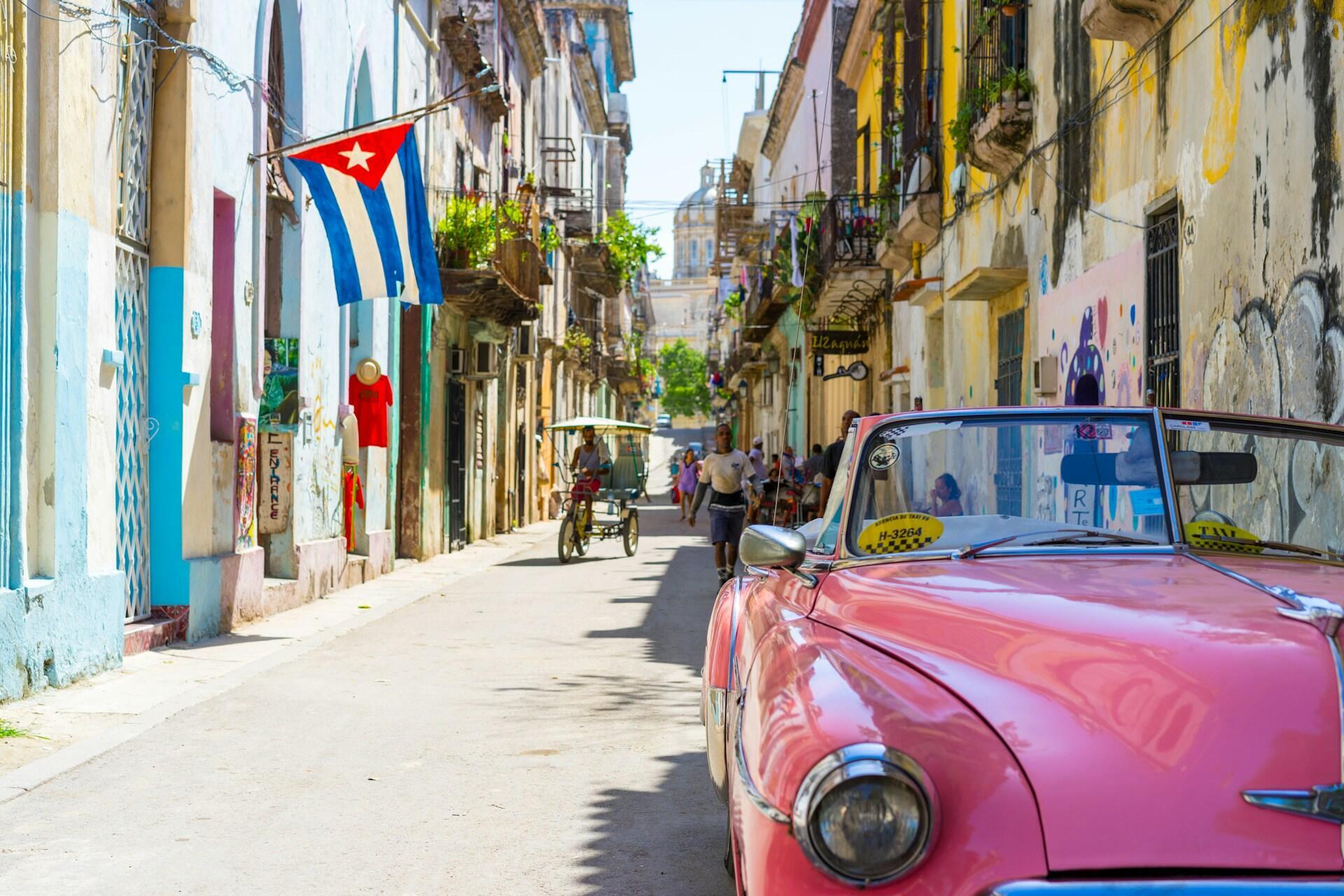 A pink car parked along the road.