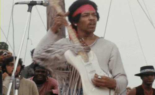 Jimi Hendrix, performing electric guitar on stage.