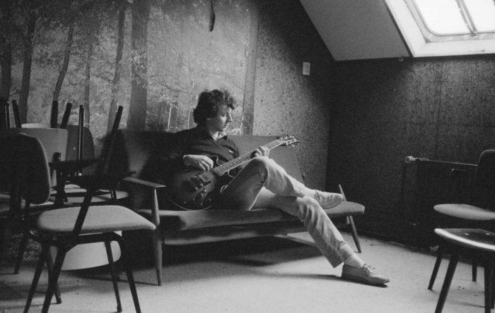 A black and white photo of a man playing a guitar.