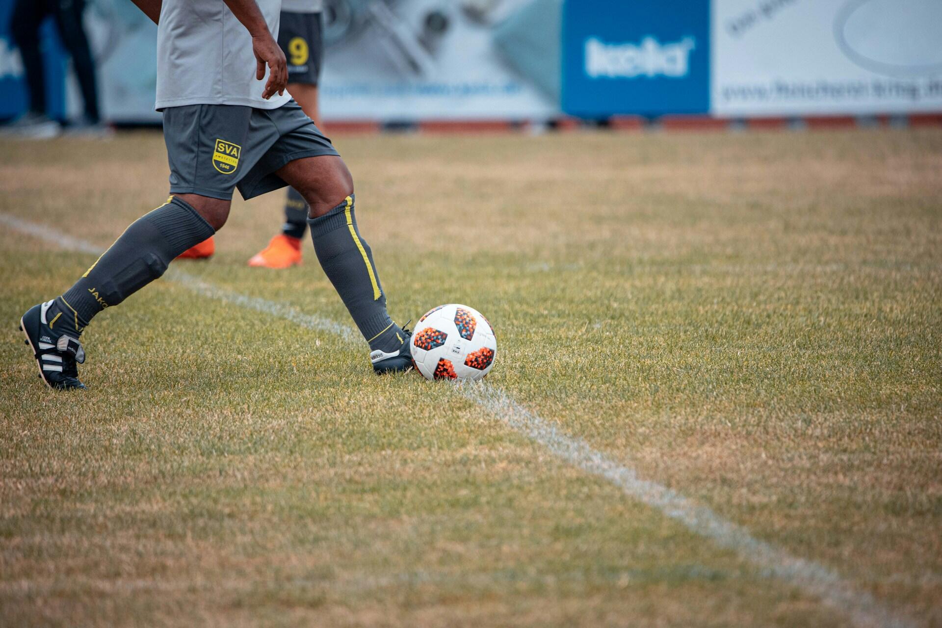 man kicking soccer ball