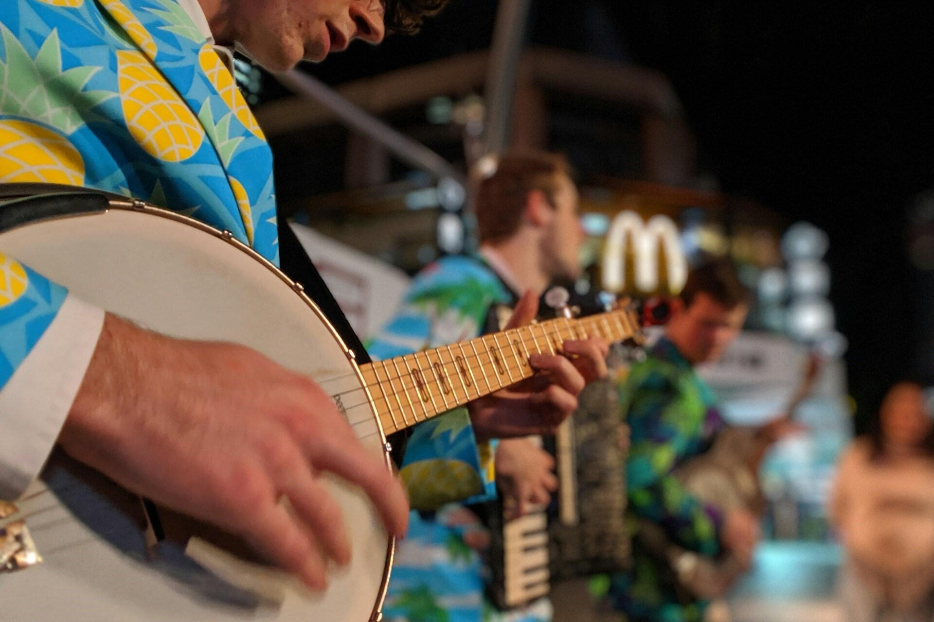 A man playing a banjo in a band.