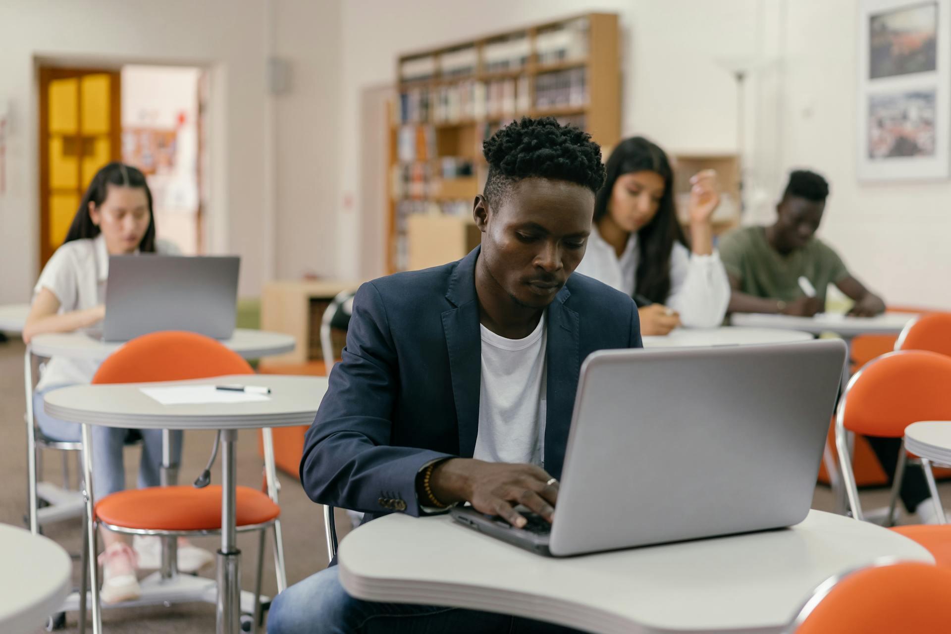 Students in a room taking a test on laptop computers
