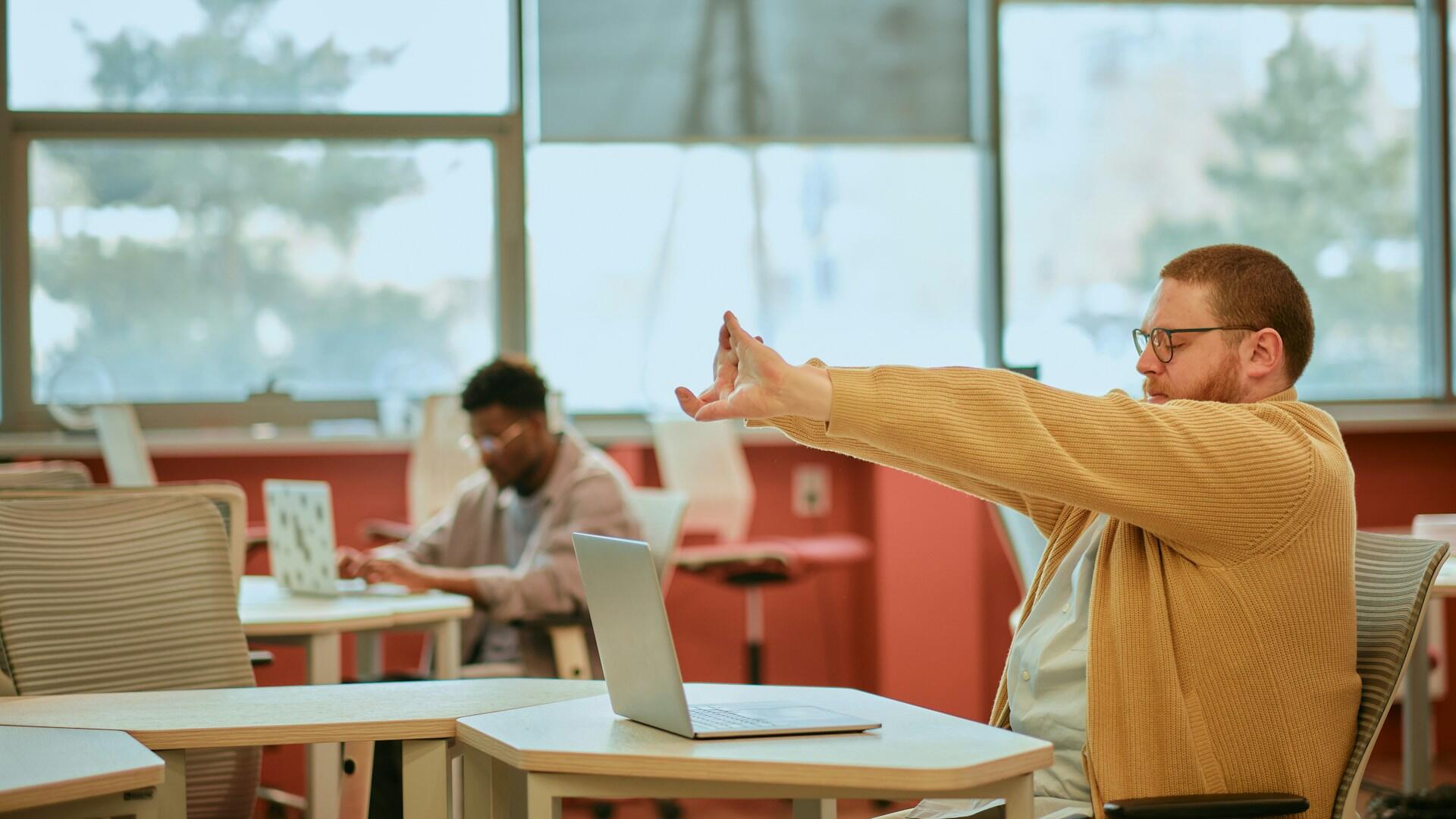 a man stretching at his desk