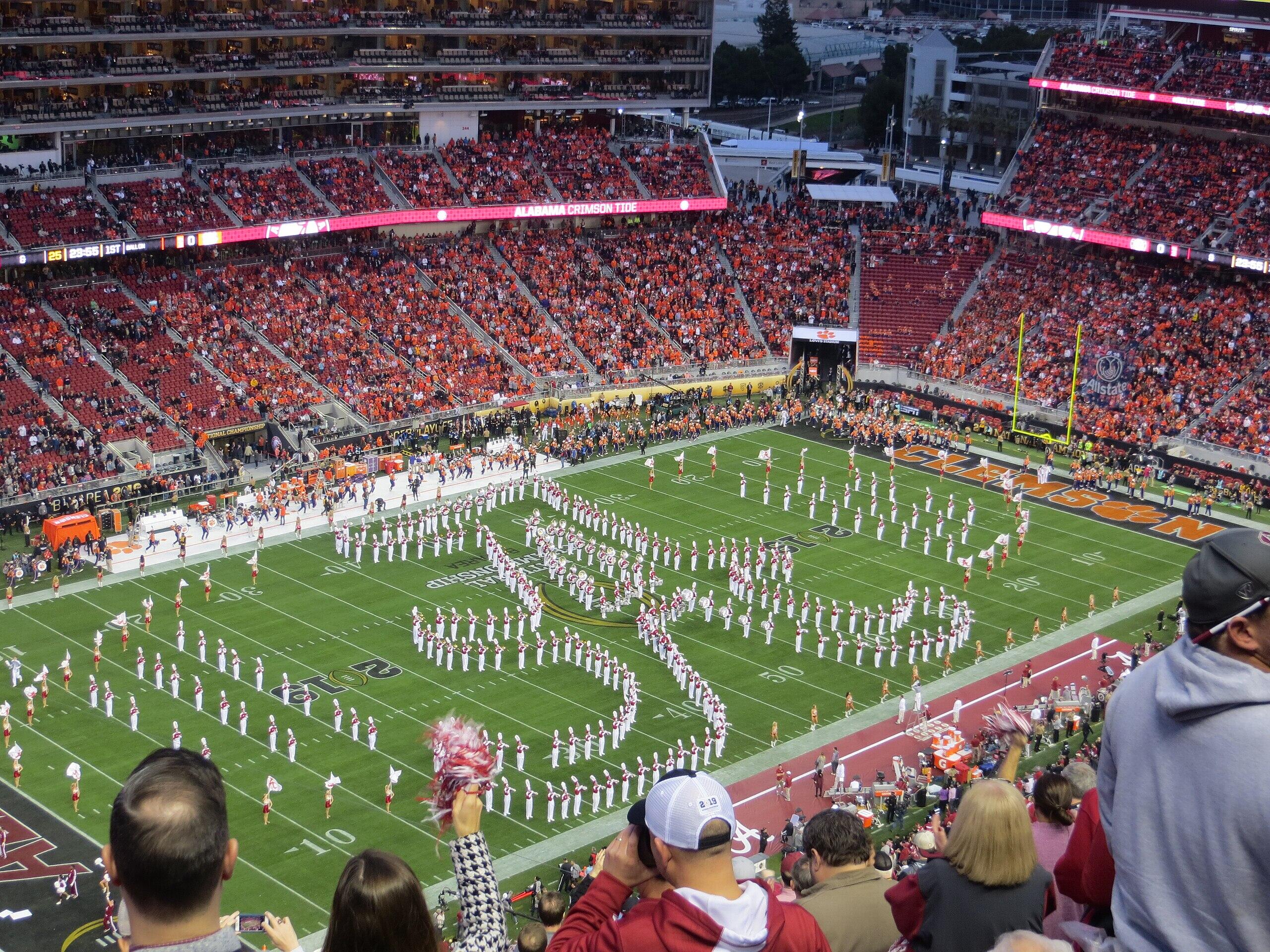 Alabama marching band in signature "A" formation on football field.