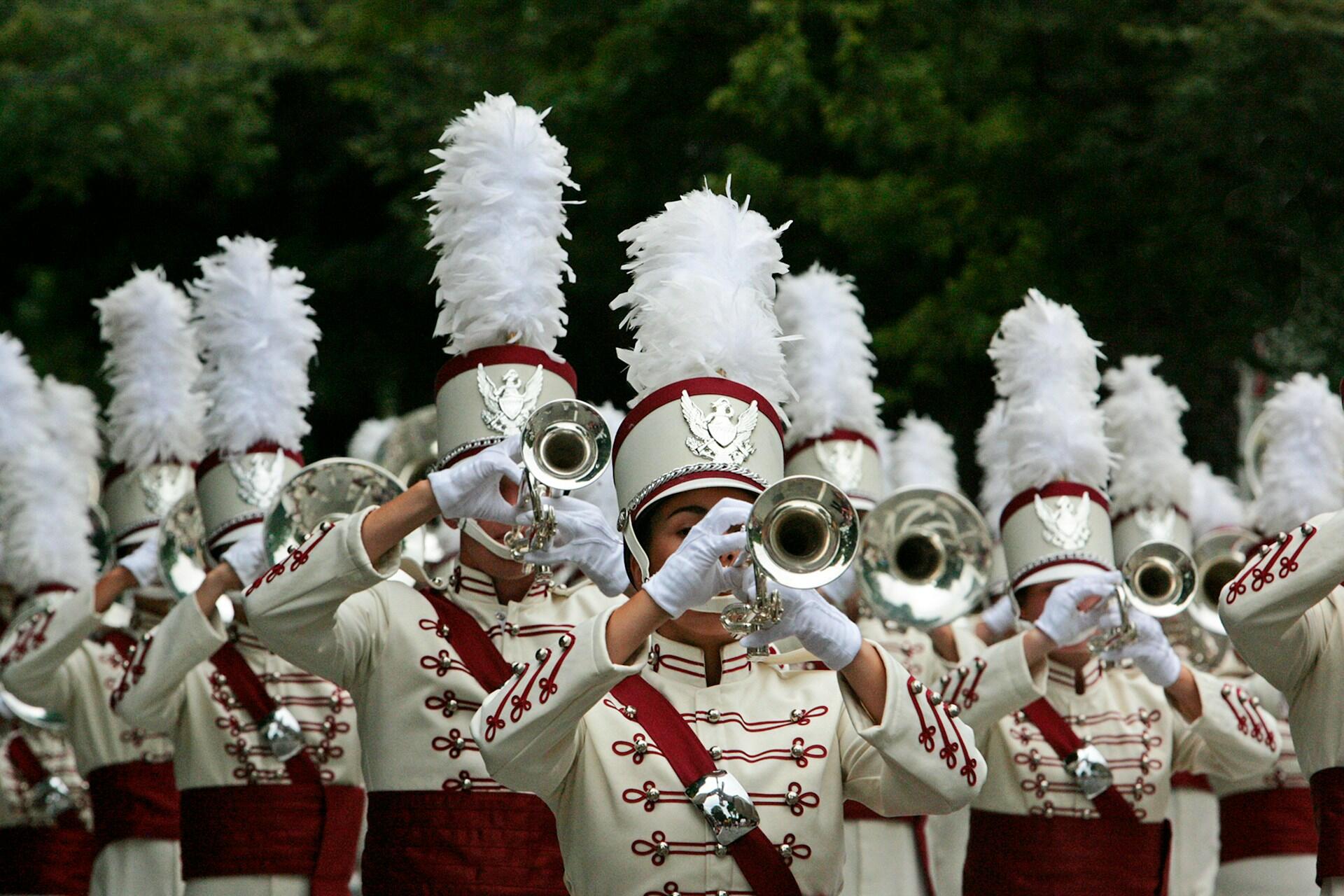 marching band with white and red uniforms and feathered caps