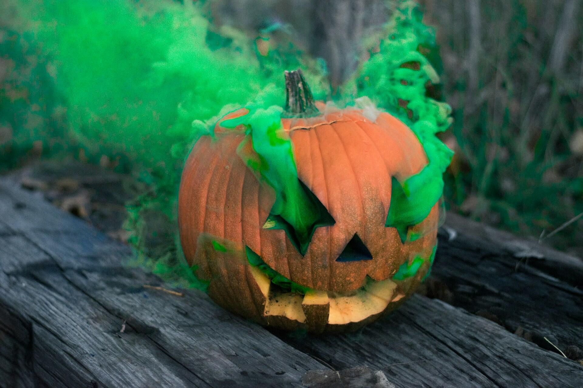 A pumpkin with green smoke coming from the eyes.