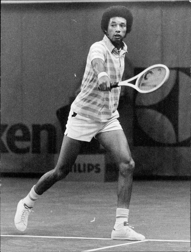black and white photo of Ashe playing tennis in 1974