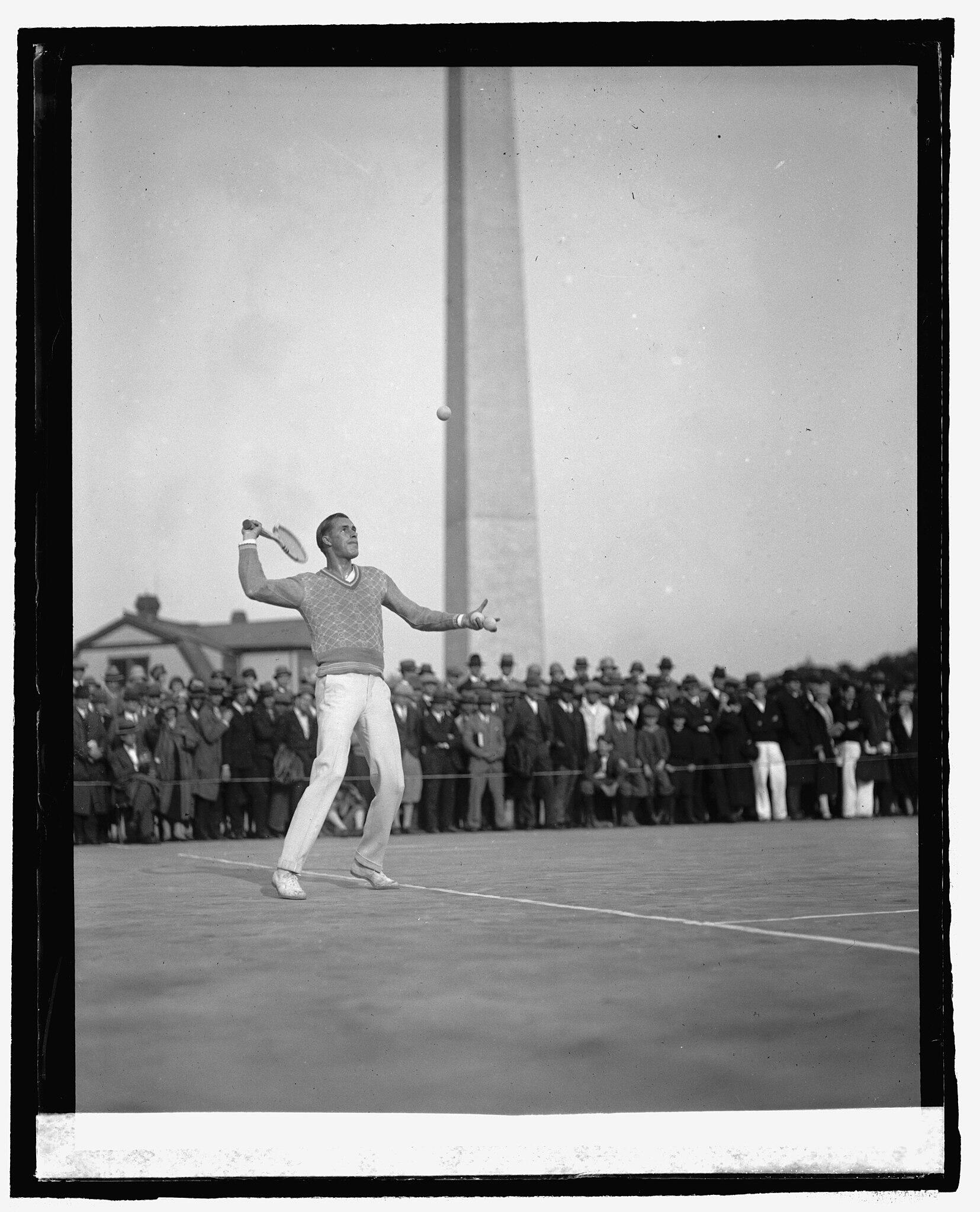 black and white photo negative of Tilden playing on a court near the Washington Monument in 1925