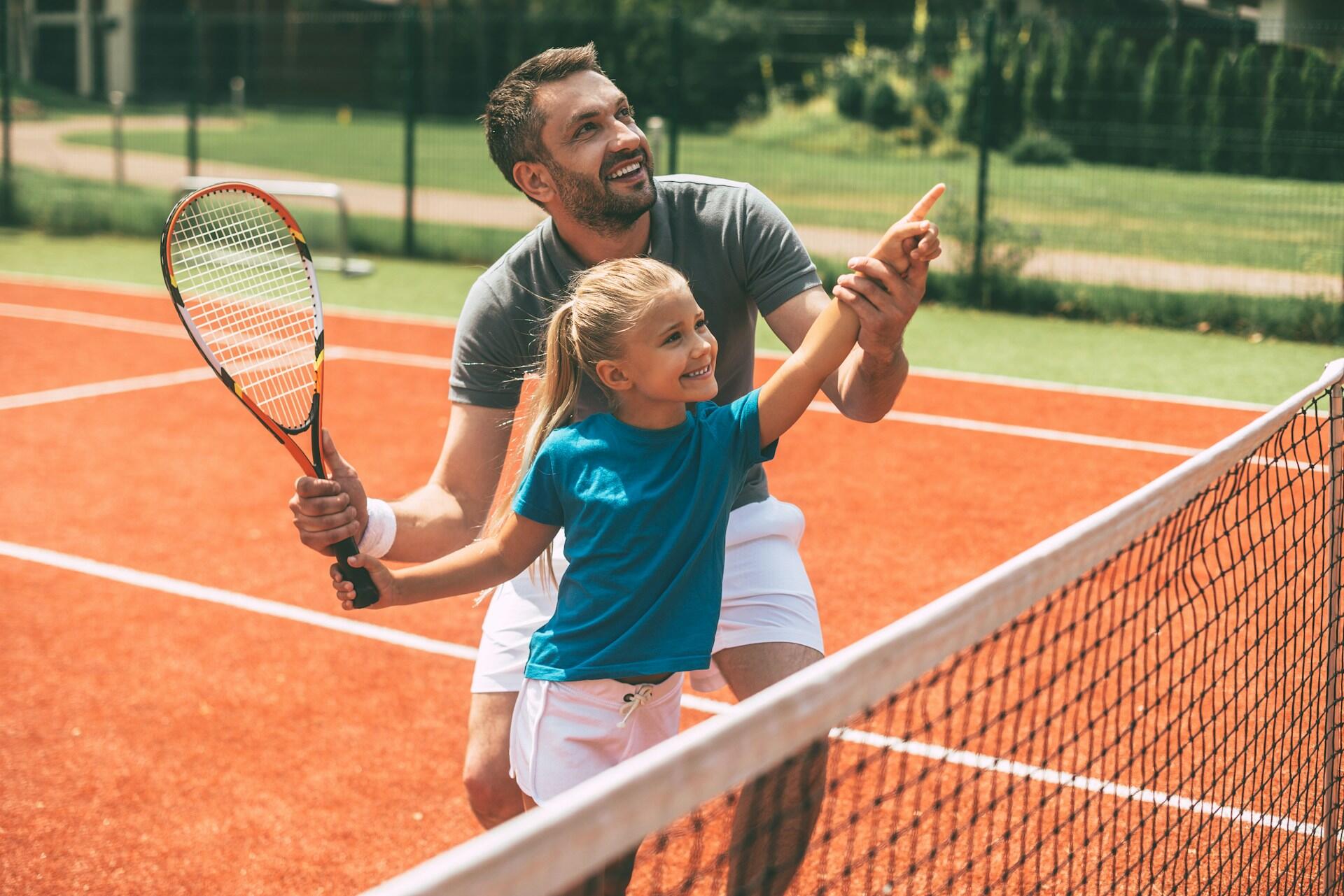 a young child learning how to play tennis