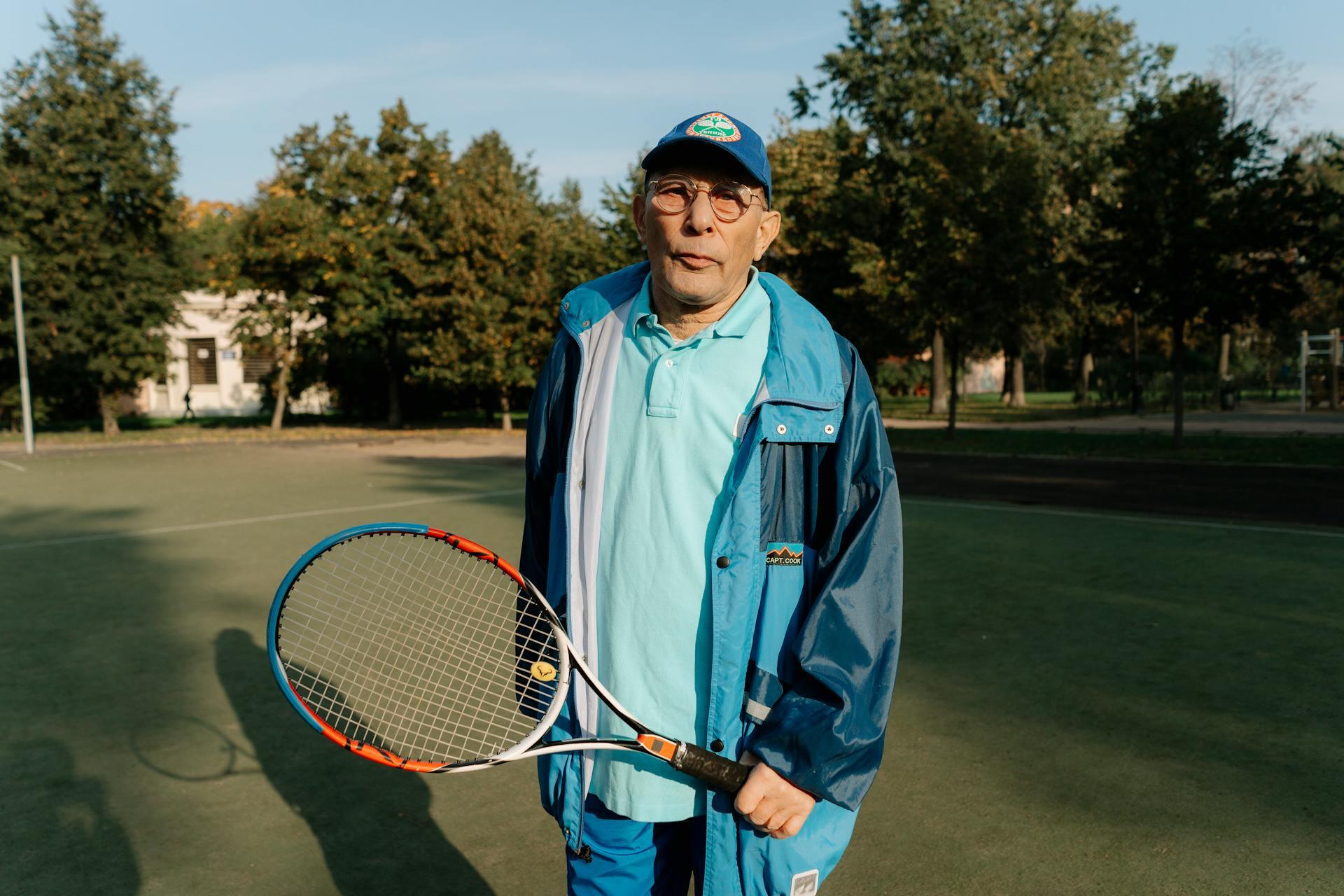 older man holding a tennis racket on a tennis court