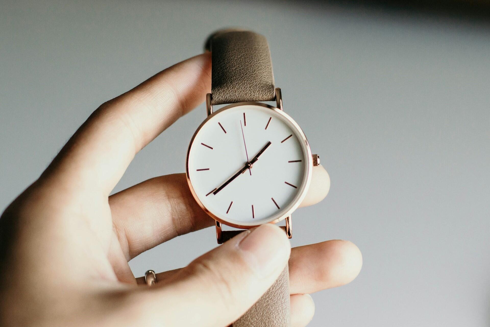 A hand holding a watch.