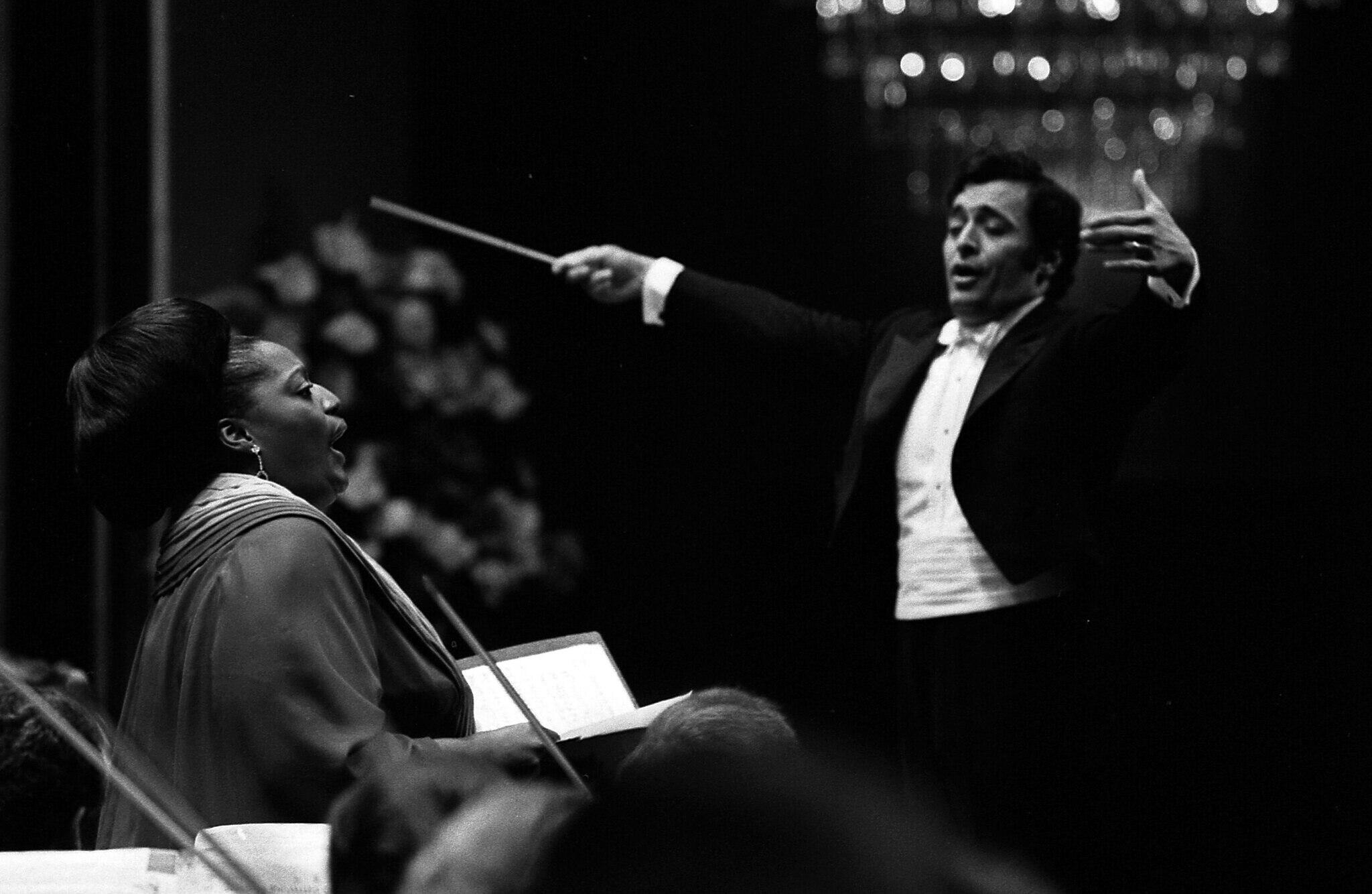 black and white photo of Mehta conducting Norman and orchestra