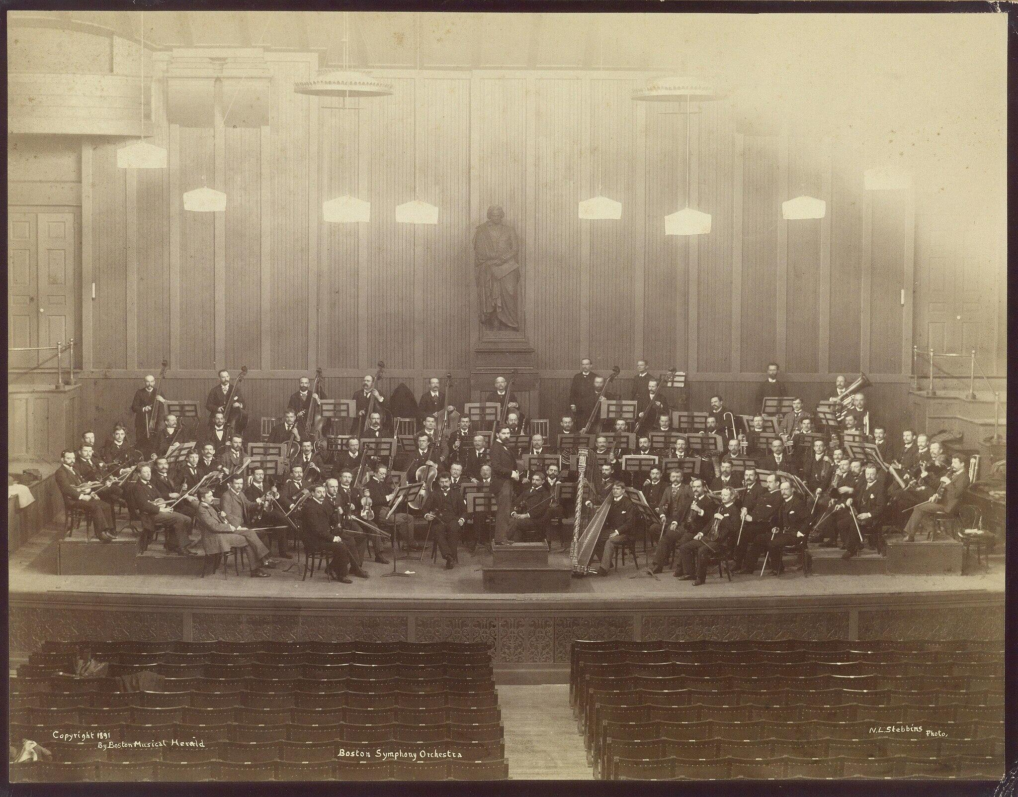 an old photograph of the Boston Symphony Orchestra on stage (1891)