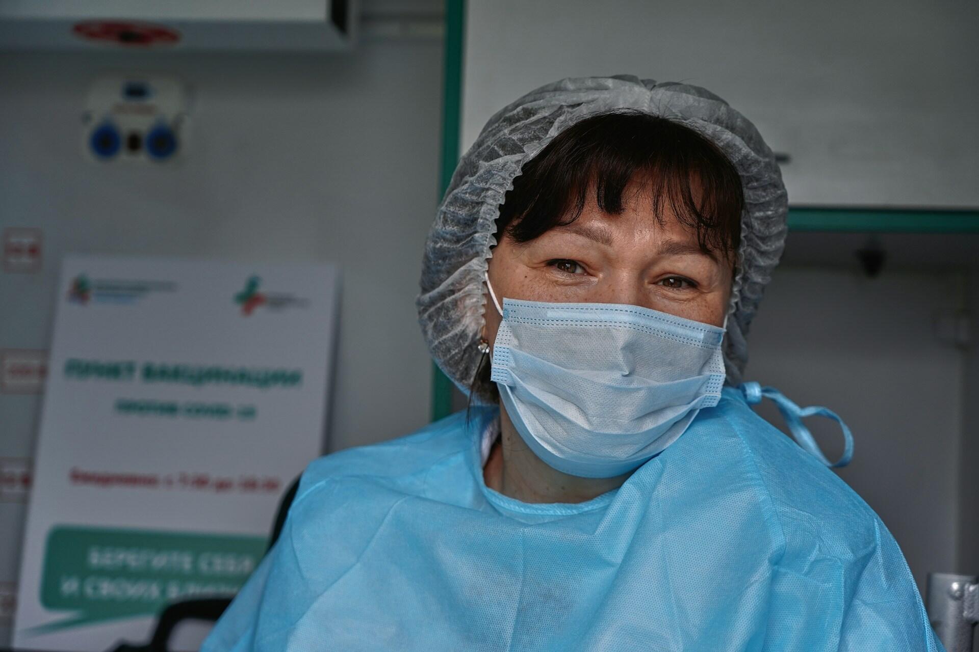 A nurse in a mask and scrubs.
