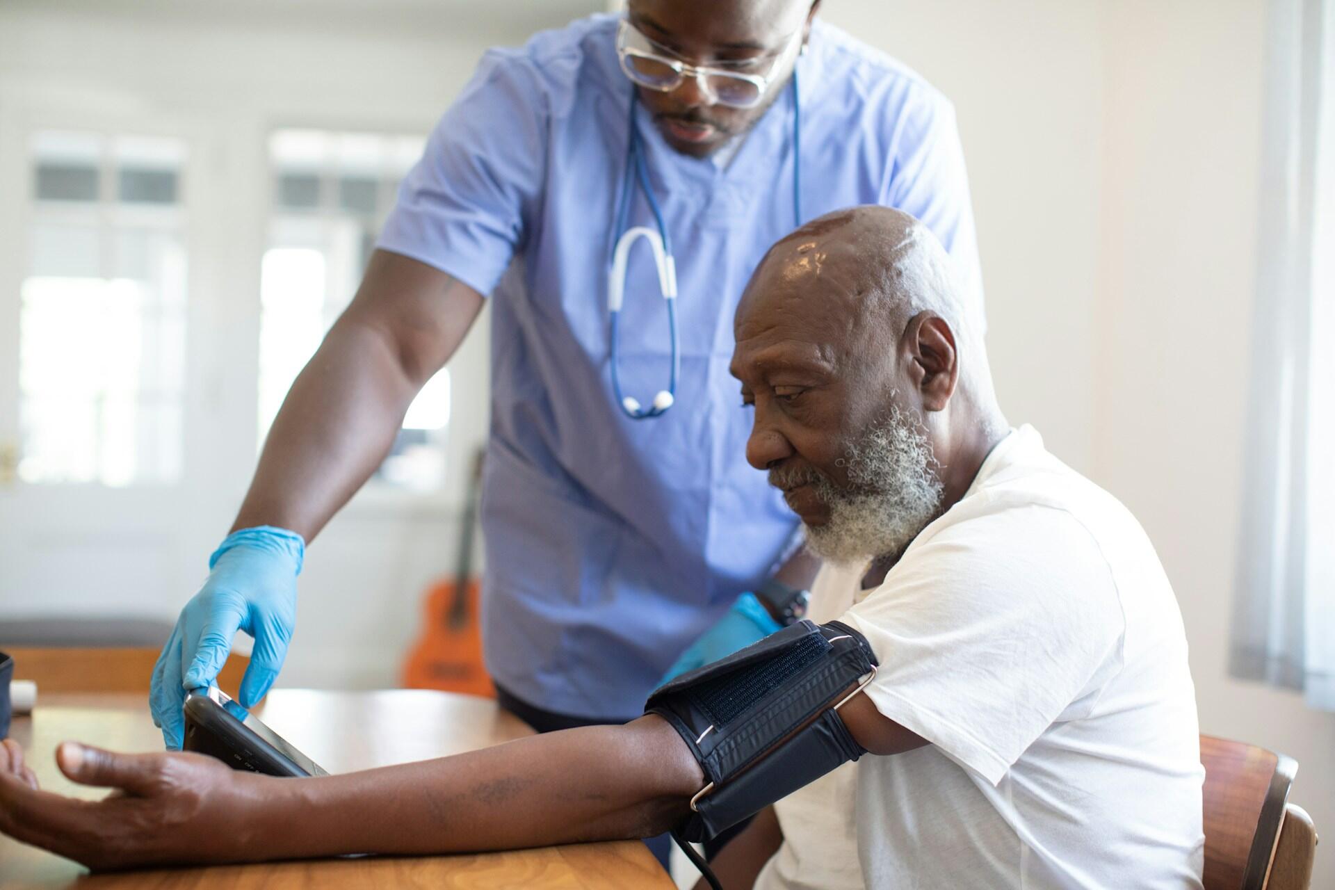 A nurse with a patient taking their blood pressure.