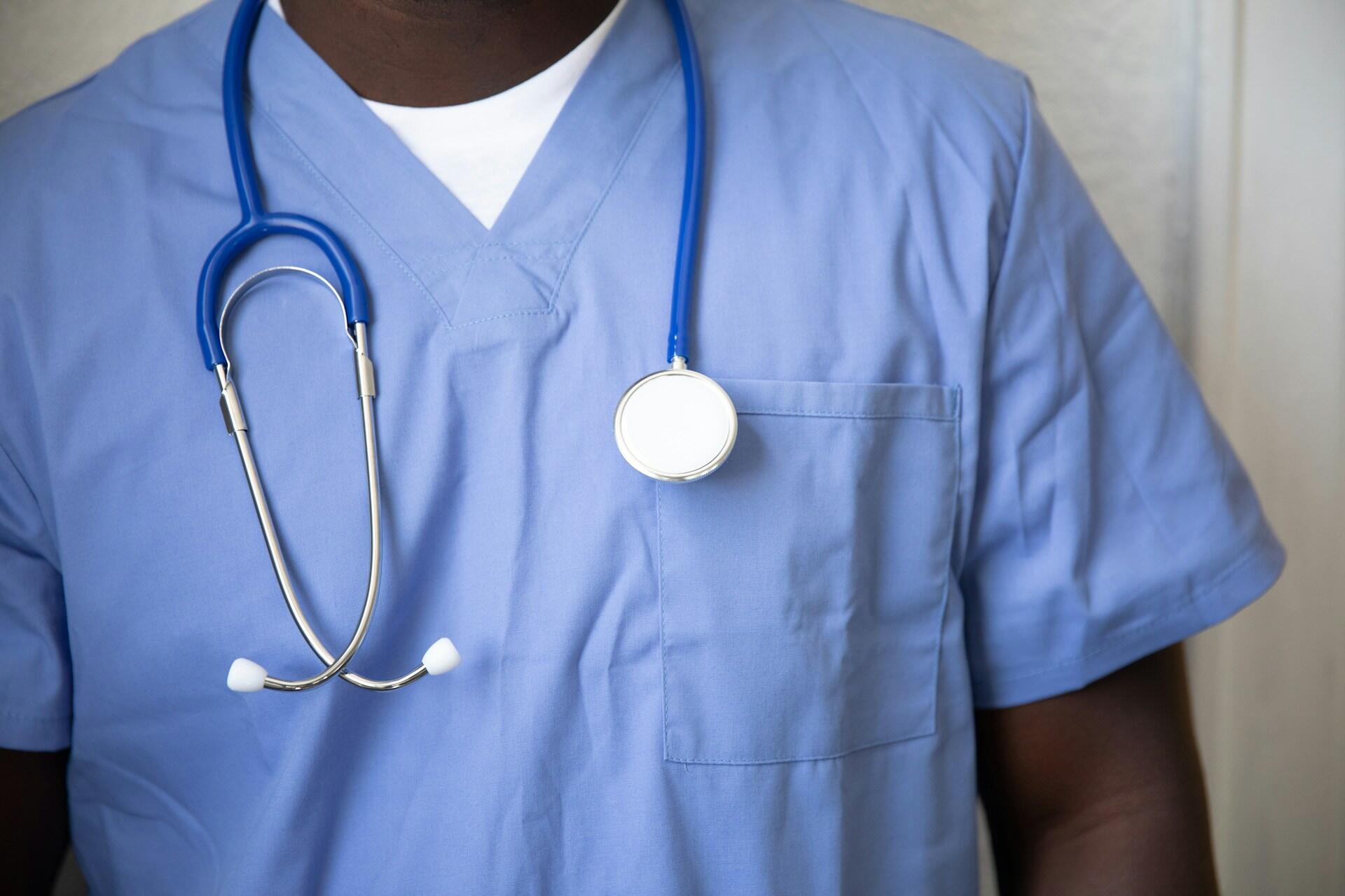 A nurse with a stethoscope on their neck.