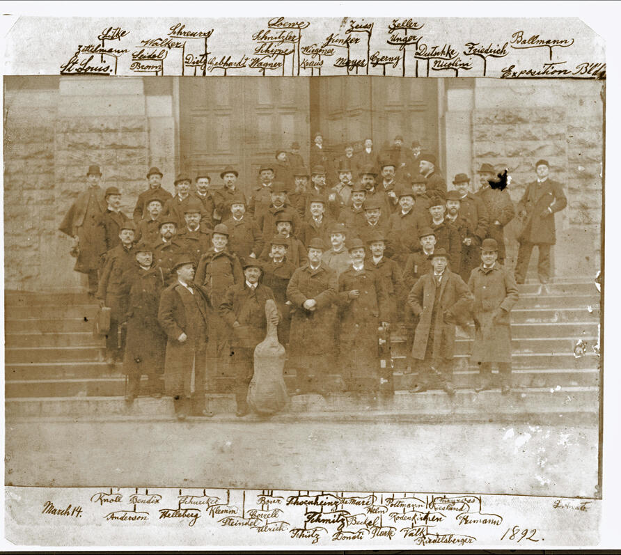 sepia photograph of the majority of the Chicago Orchestra musicians in 1892. Handwritten labels surround the photo, naming each player.