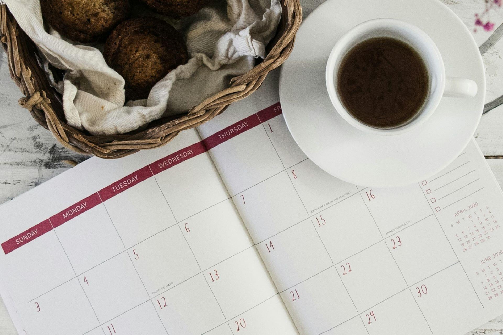 A diary or planner with a cup of coffee.