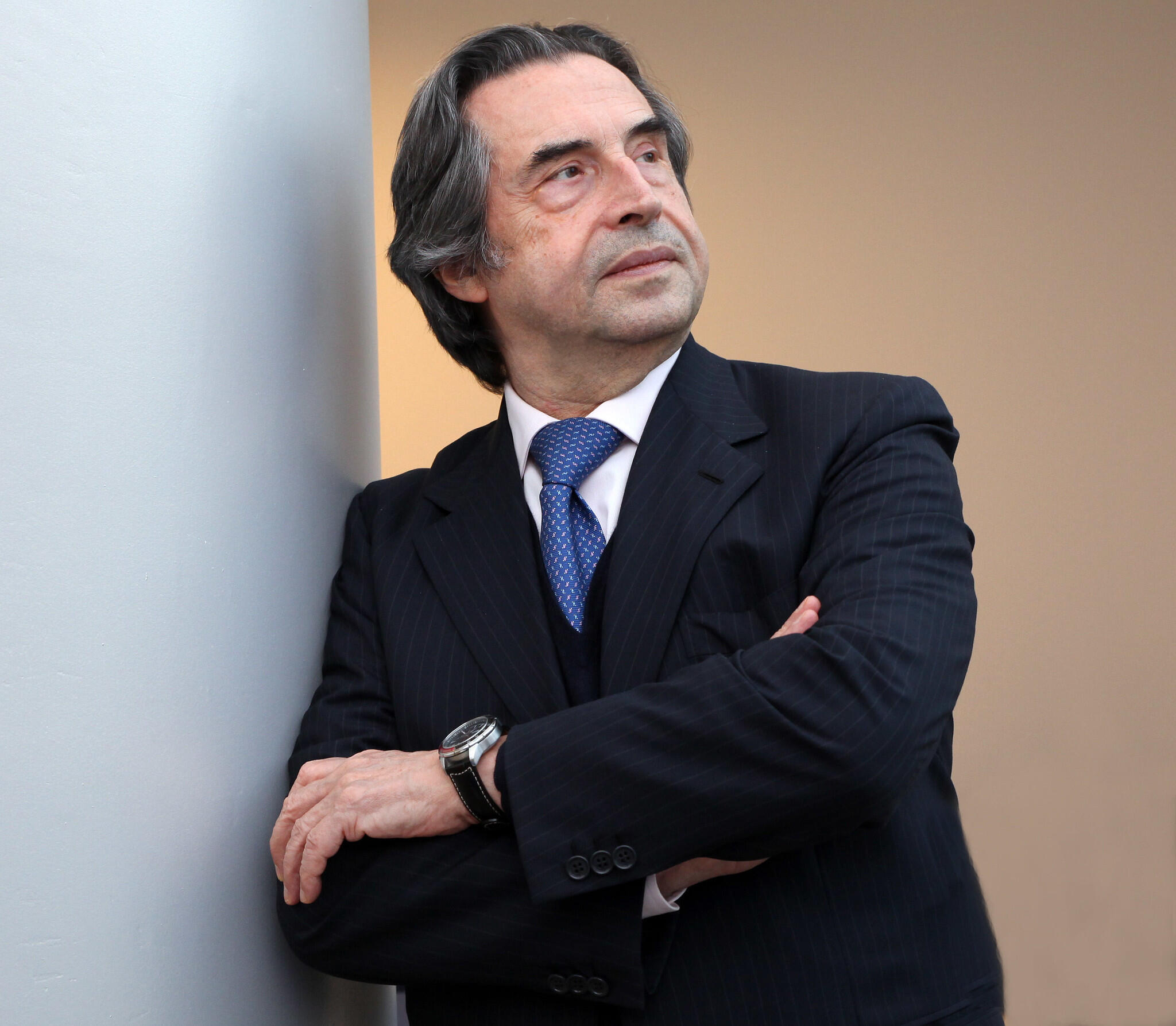 Riccardo leaning with his arms crossed.
