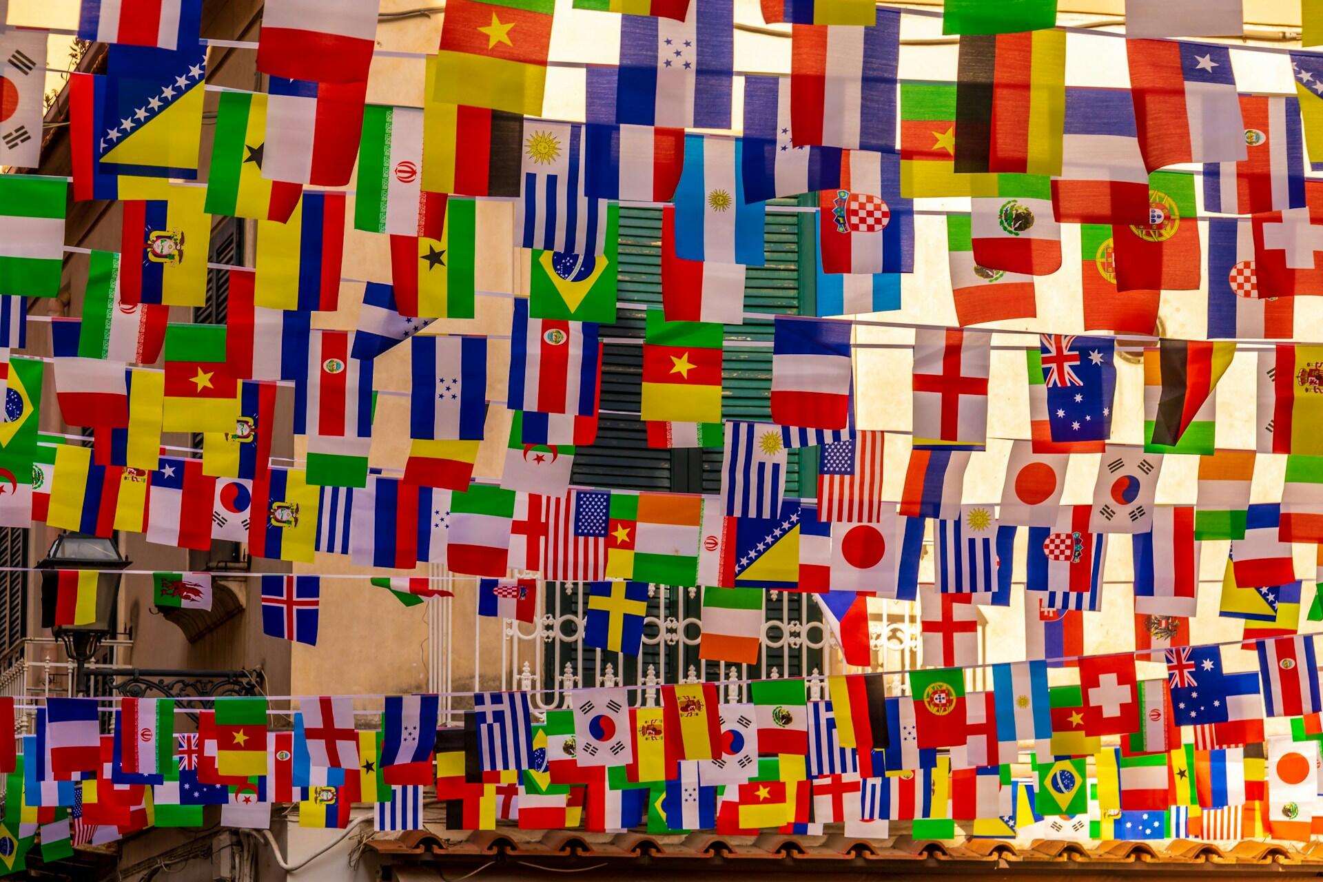 A bunch of flags from around the world hanging.