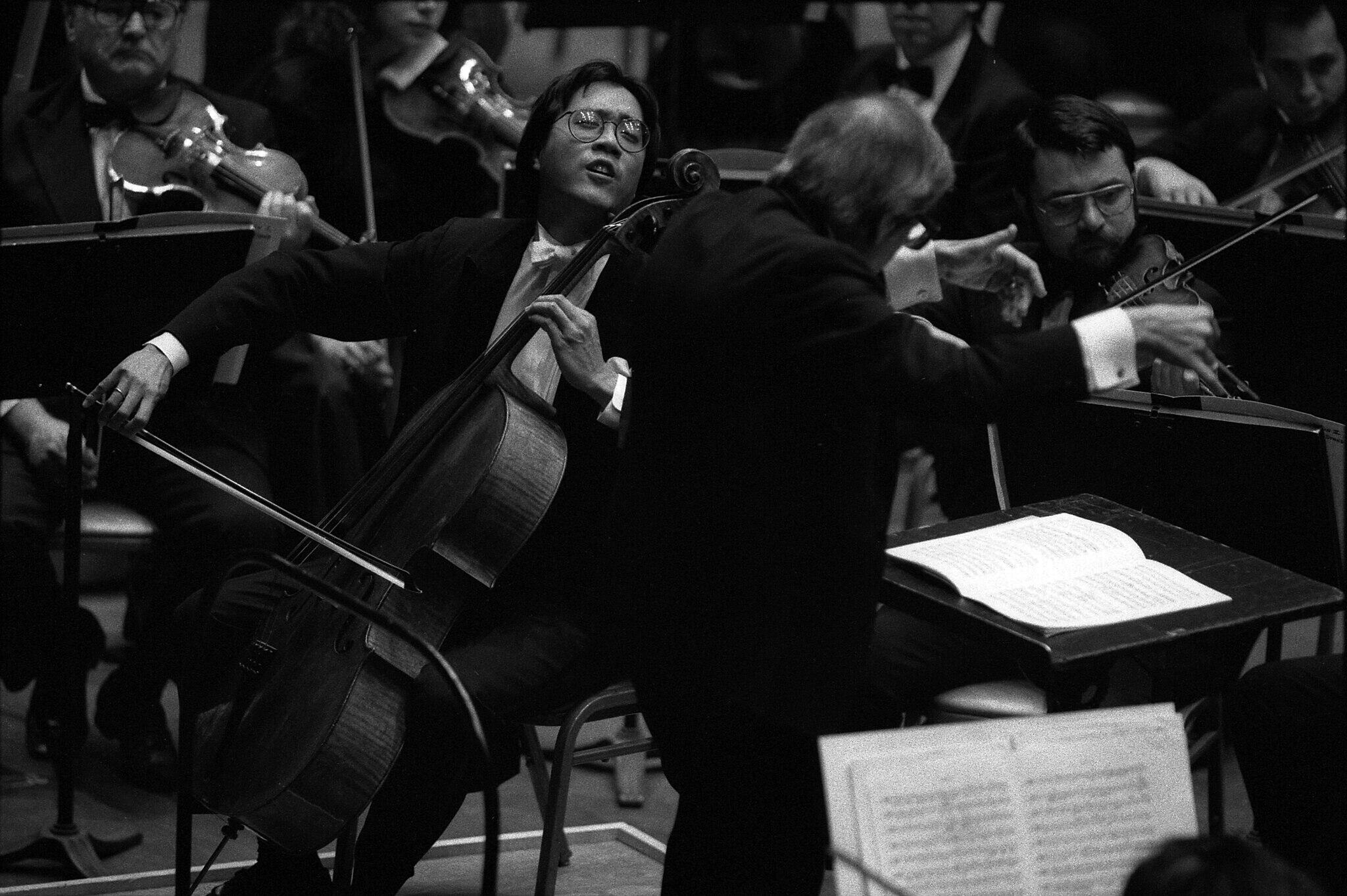 black and white photo of Yo-Yo Ma performing with the orchestra