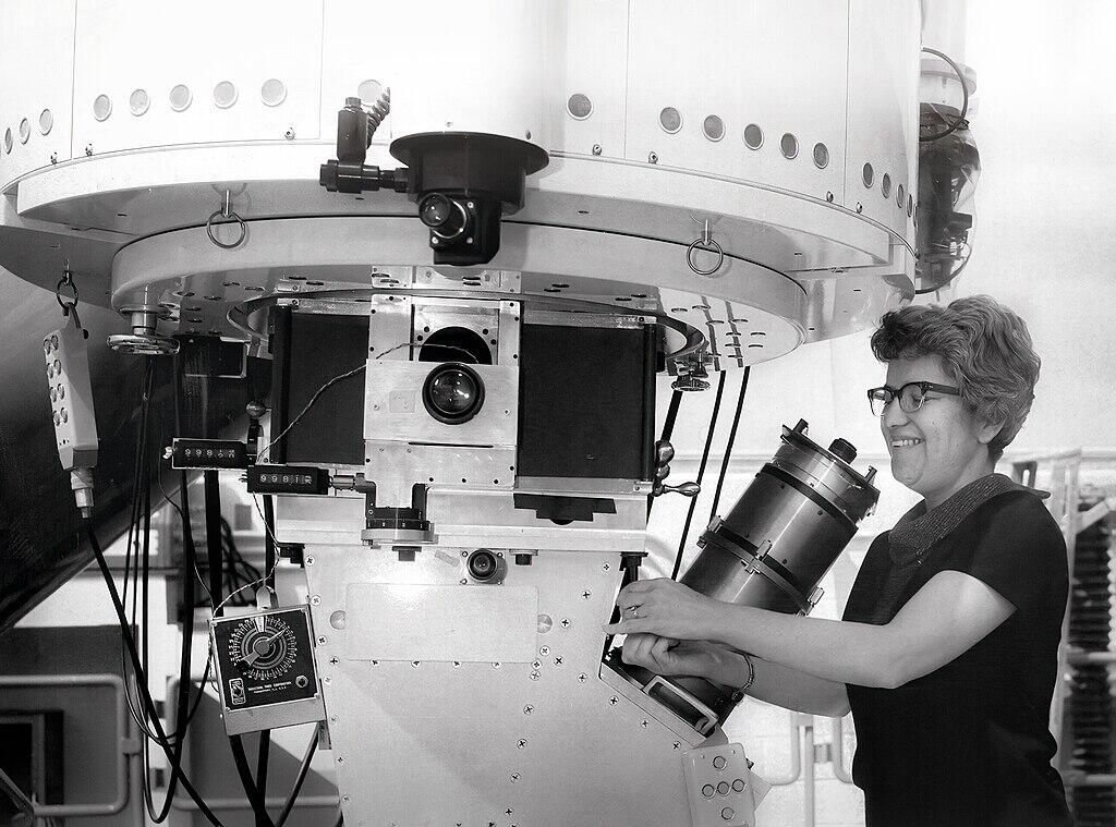 Vera Rubin holding a telescope.