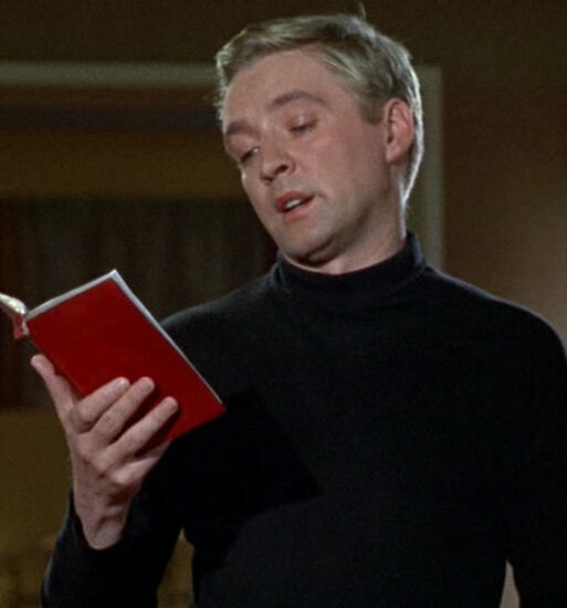 film still from the 1966 production showing Guy reading from a book