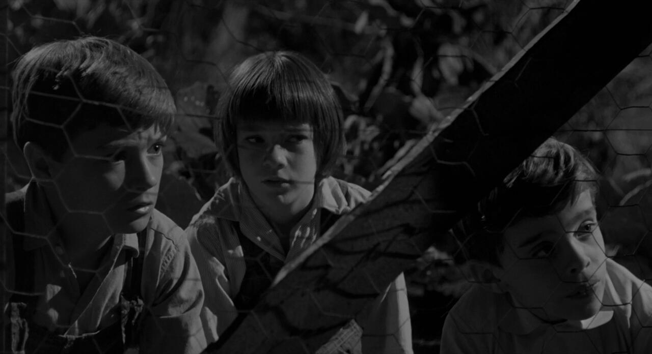 Jem, Scout, and Dill looking for Boo Radley at night.