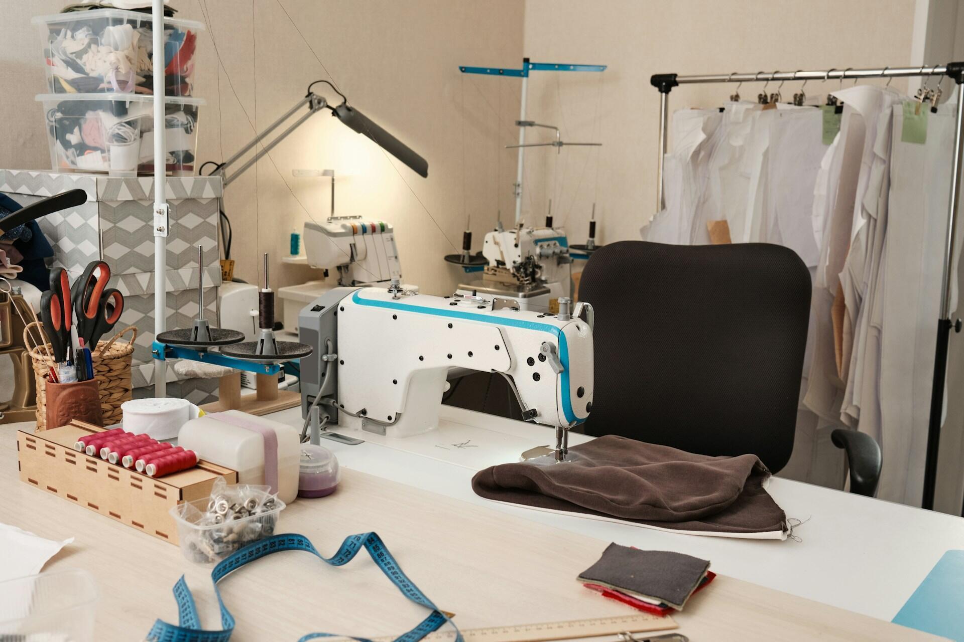 A sewing room with a sewing machine on a work table. 