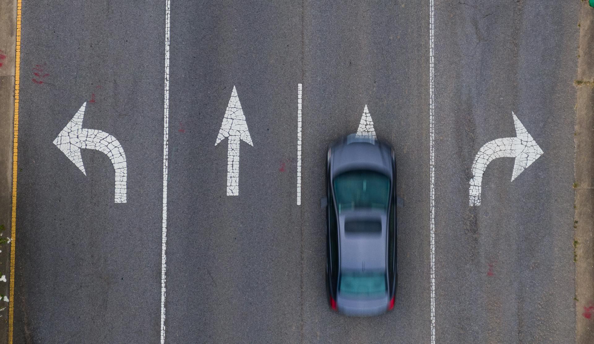 car driving in a lane with a painted direction marker