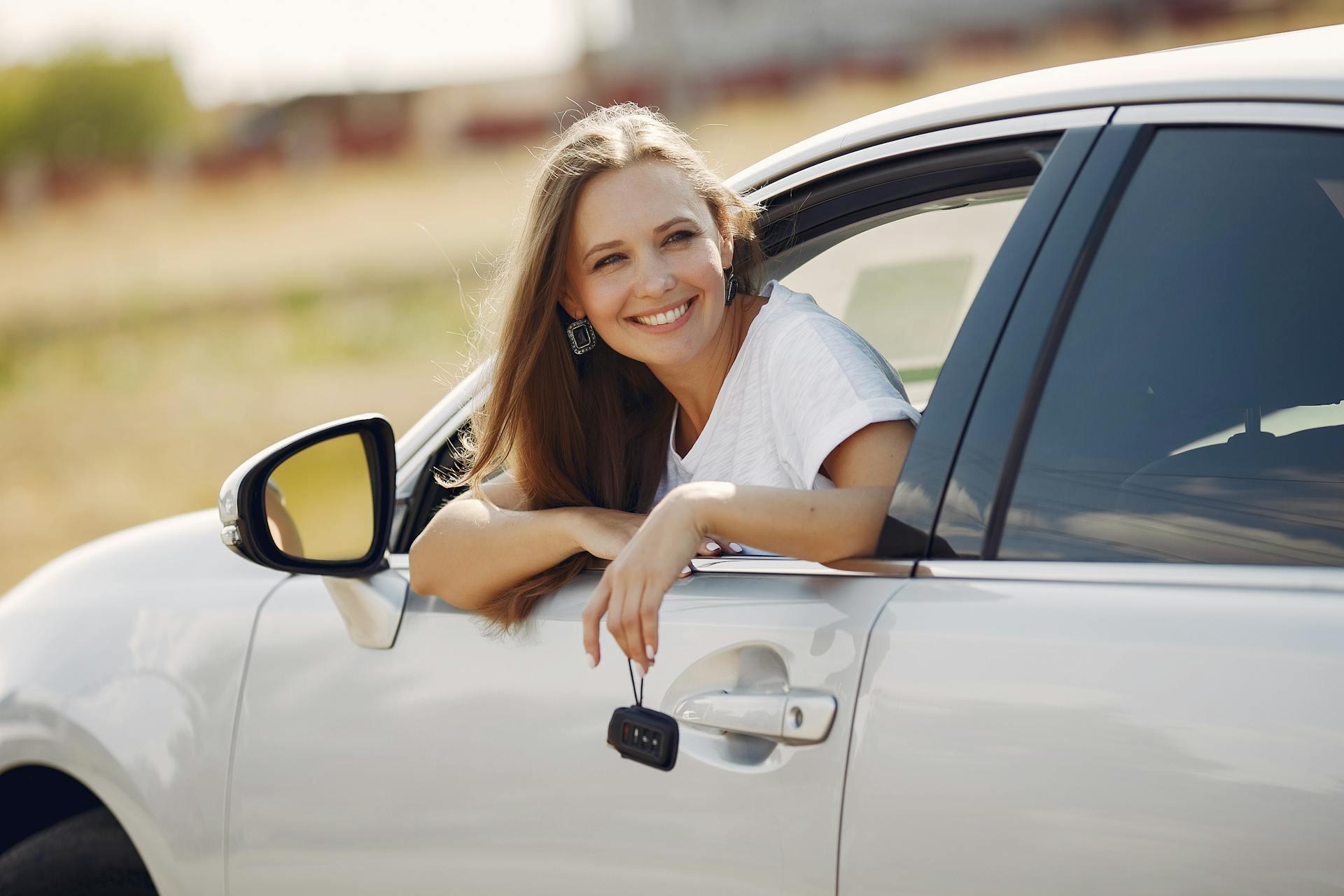 driver leaning out of the driver's side window and smiling while the car is parked
