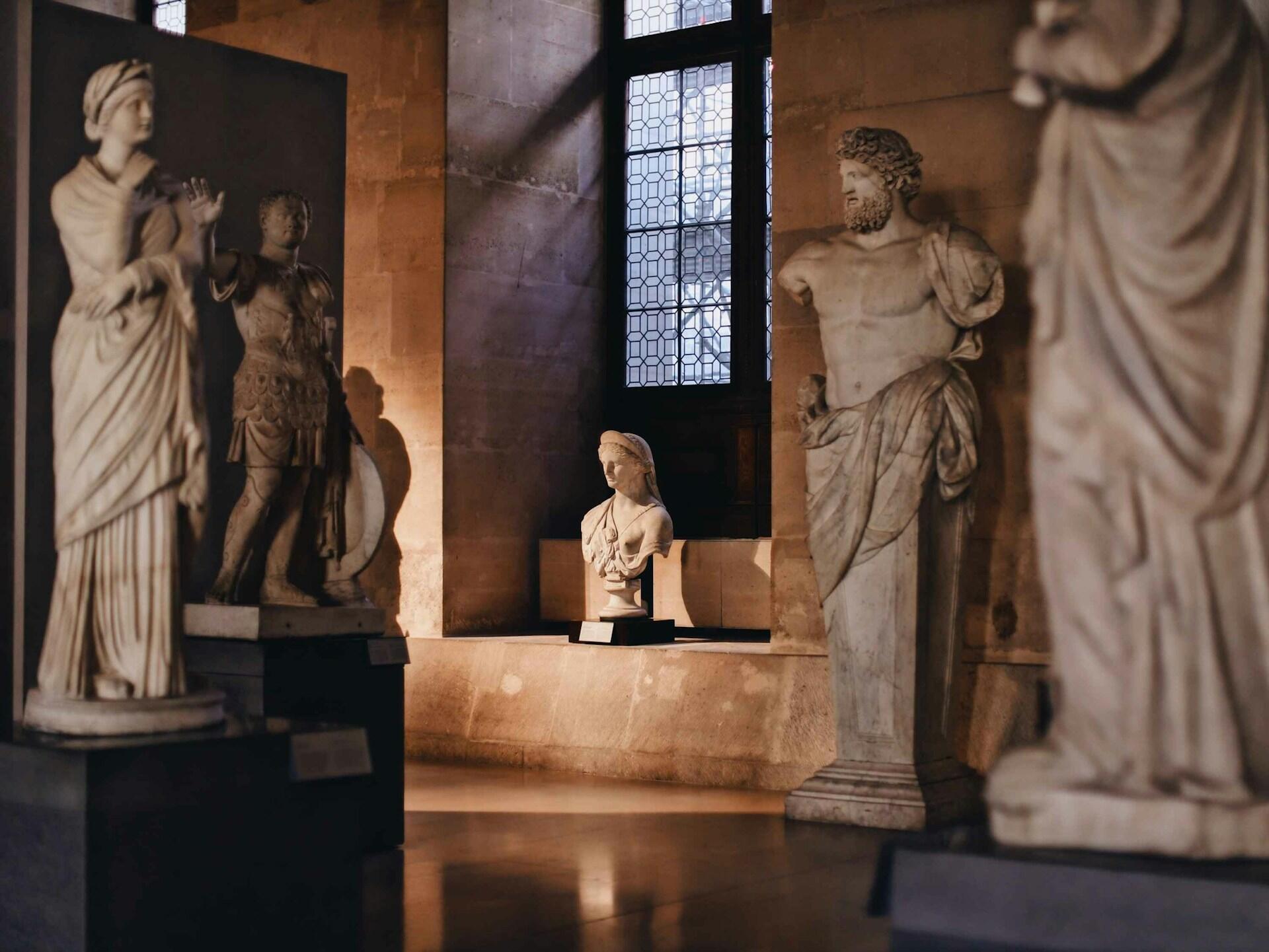 Five marble statues in a museum.