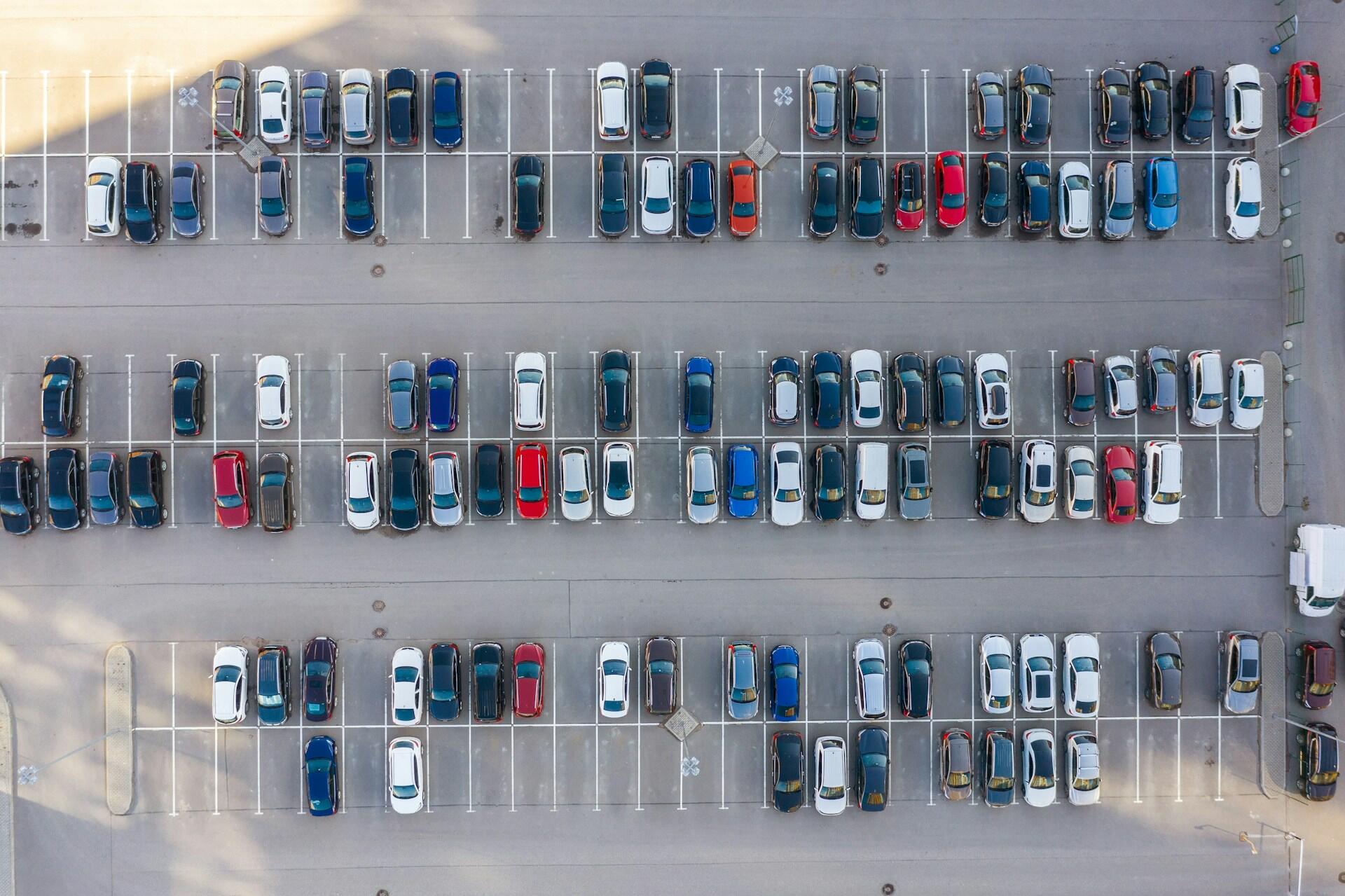overhead view of a car parking lot with lots of cars