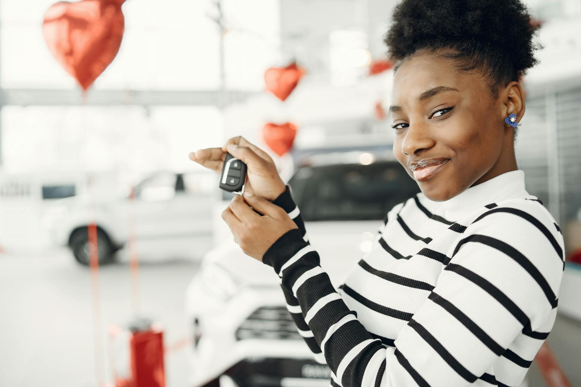 a teen driver holding the car key for her new car