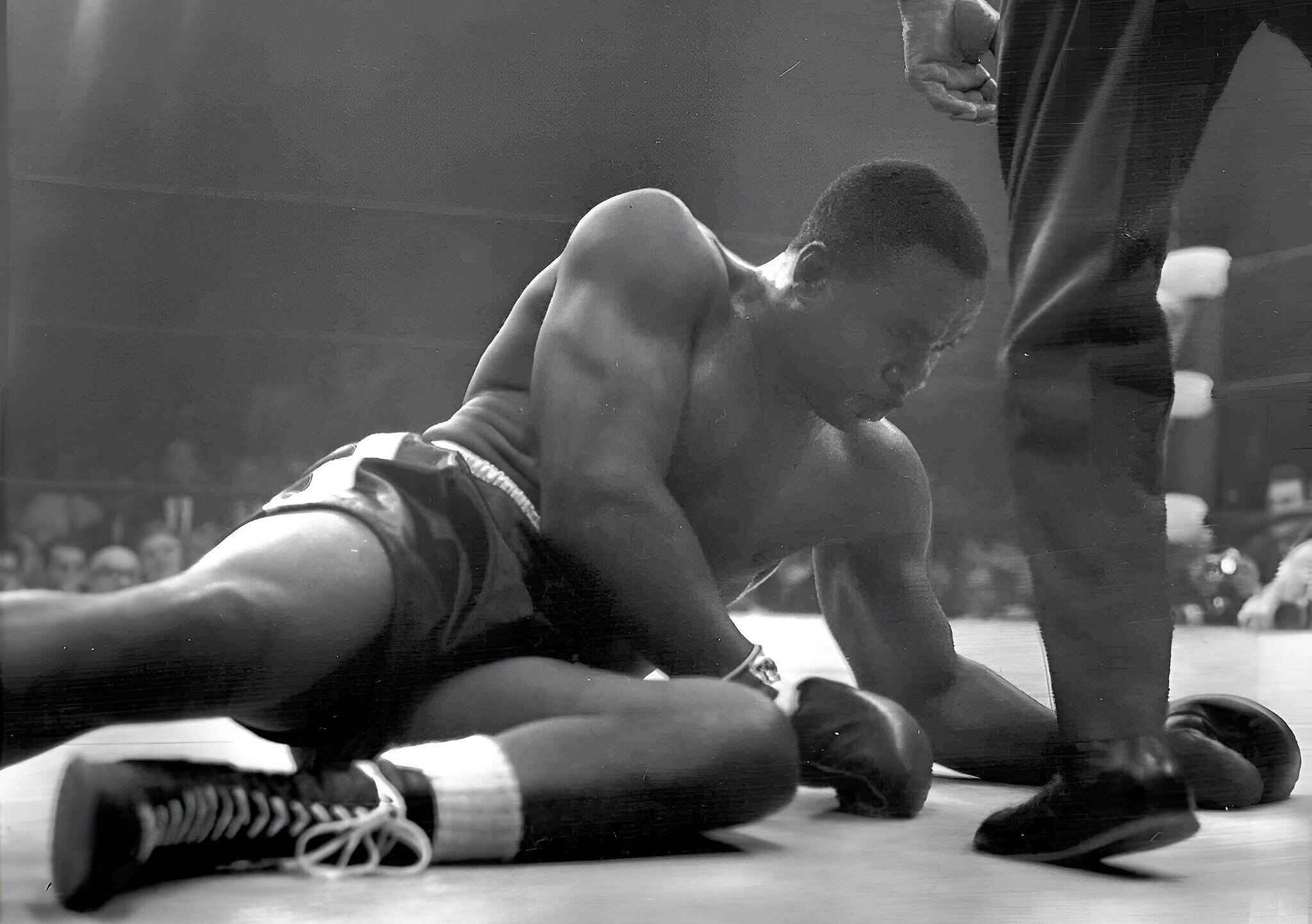 Sonny Liston trying to get back up in a boxing ring.