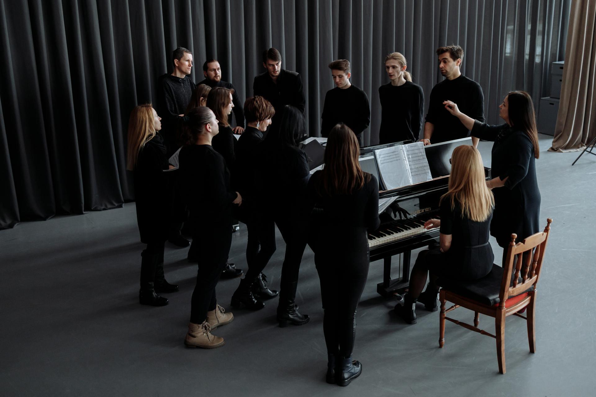 group of chorus students practicing with a piano