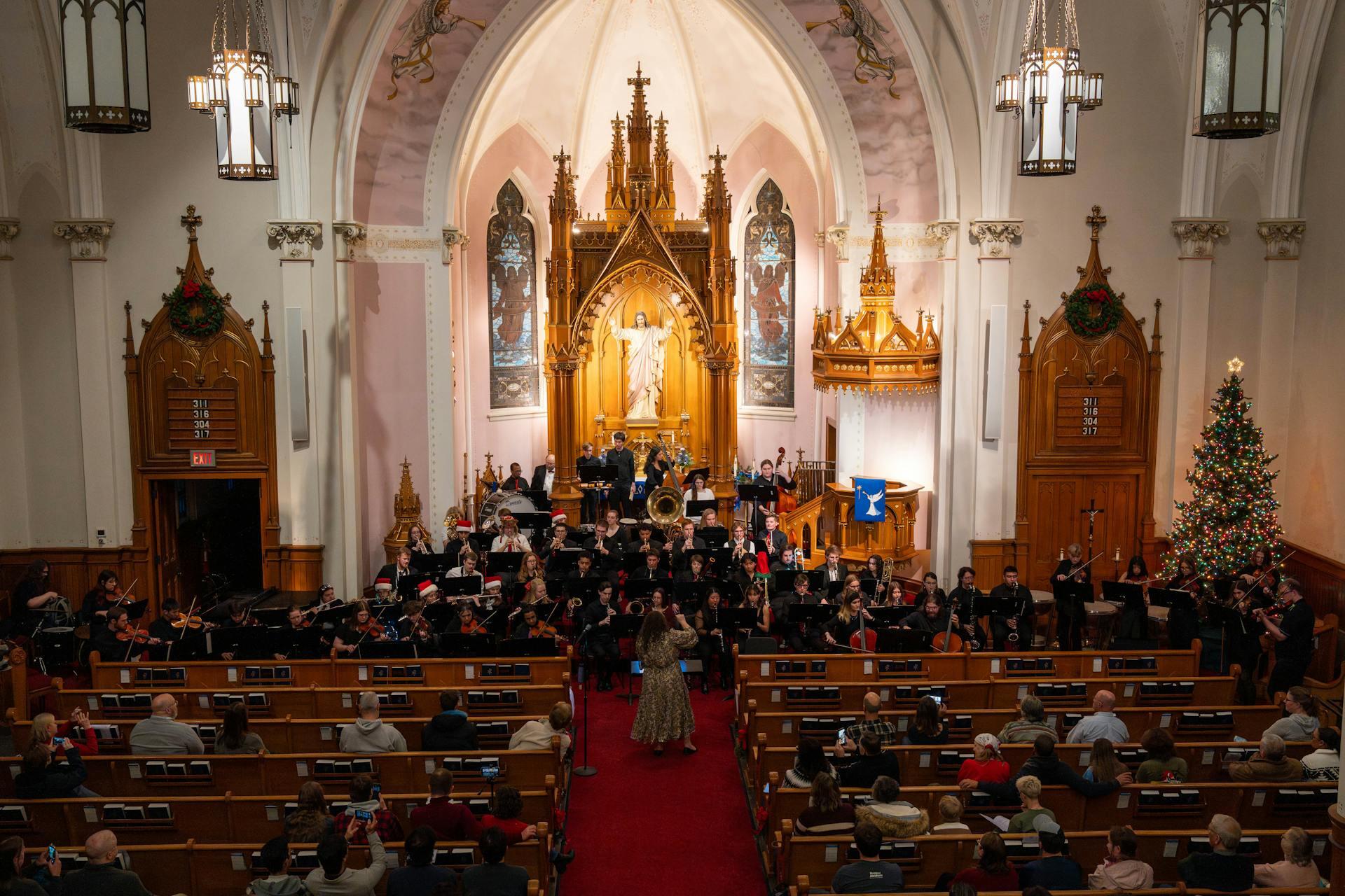 large holiday concert choir performing with instruments and singing at the front of a church