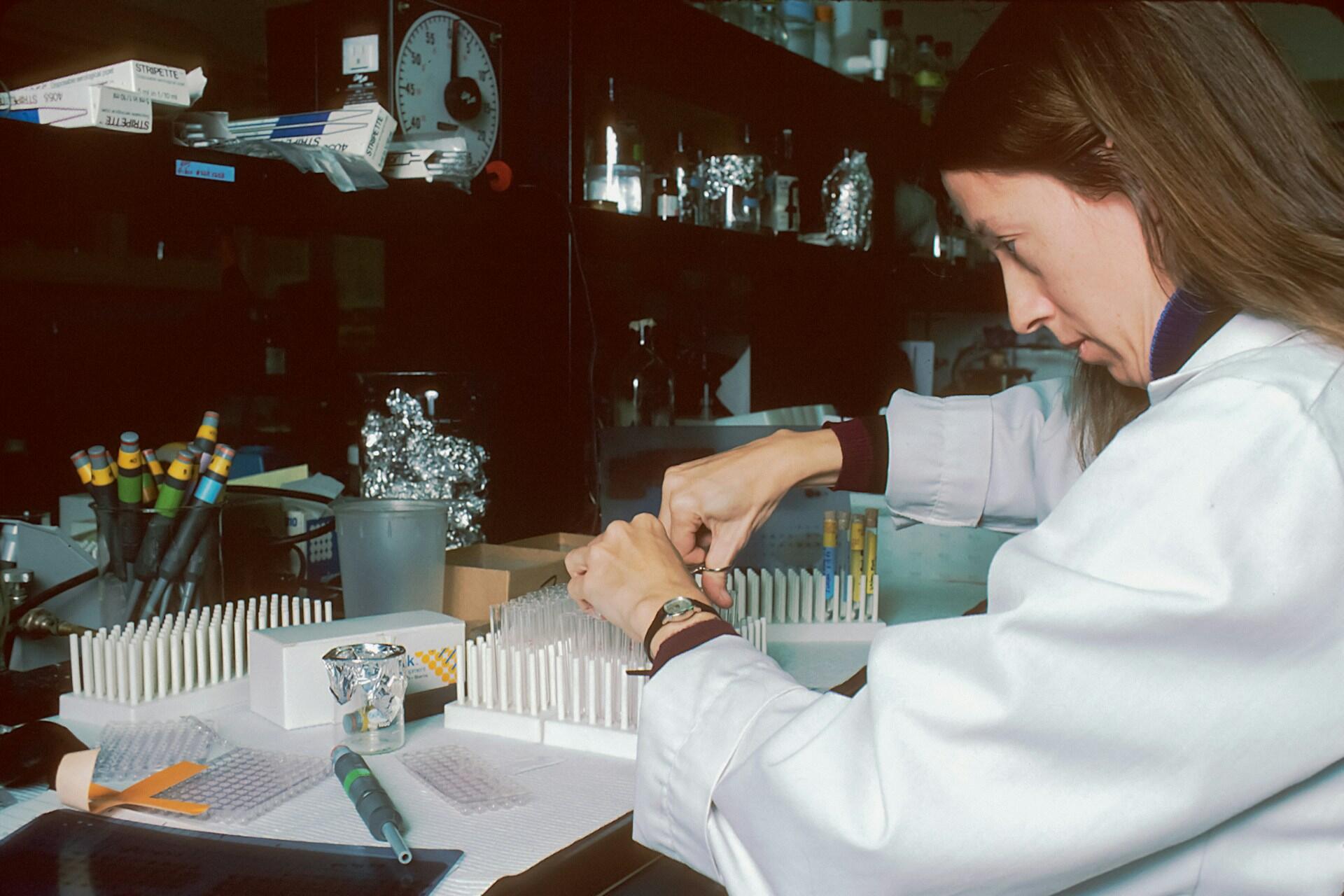 A female scientist in a lab coat performing an experiment.