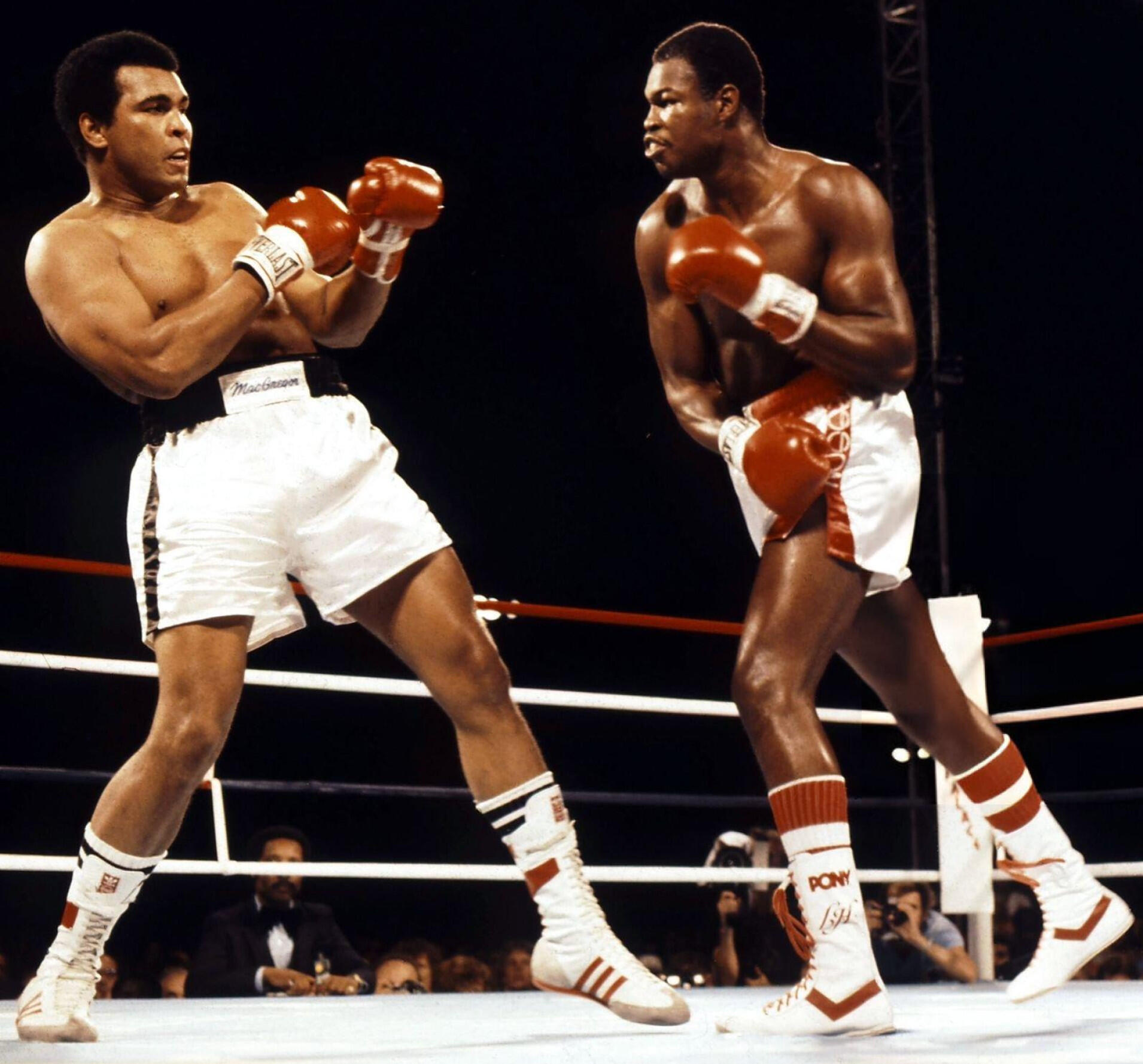 Muhammad Ali vs Larry Holmes in a boxing match.
