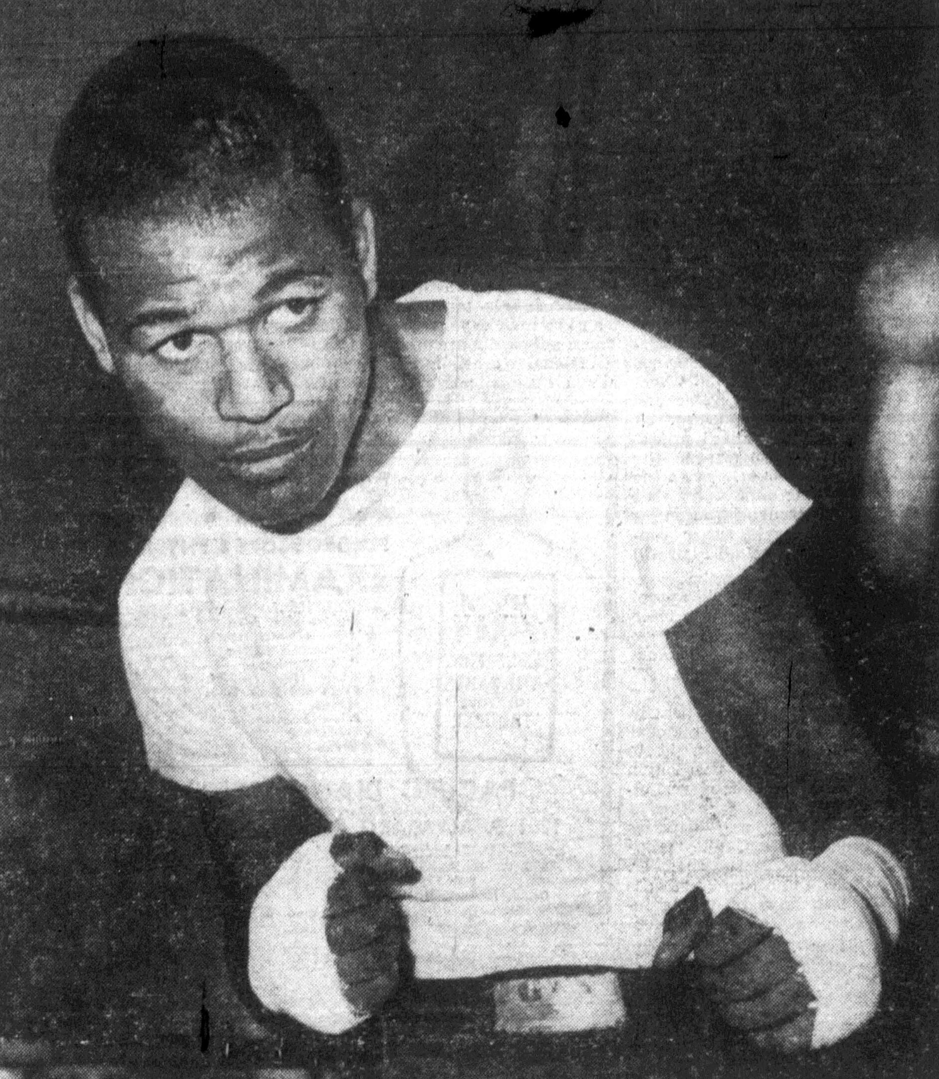 A black and white photo of Sugar Ray Robinson in a boxing pose.