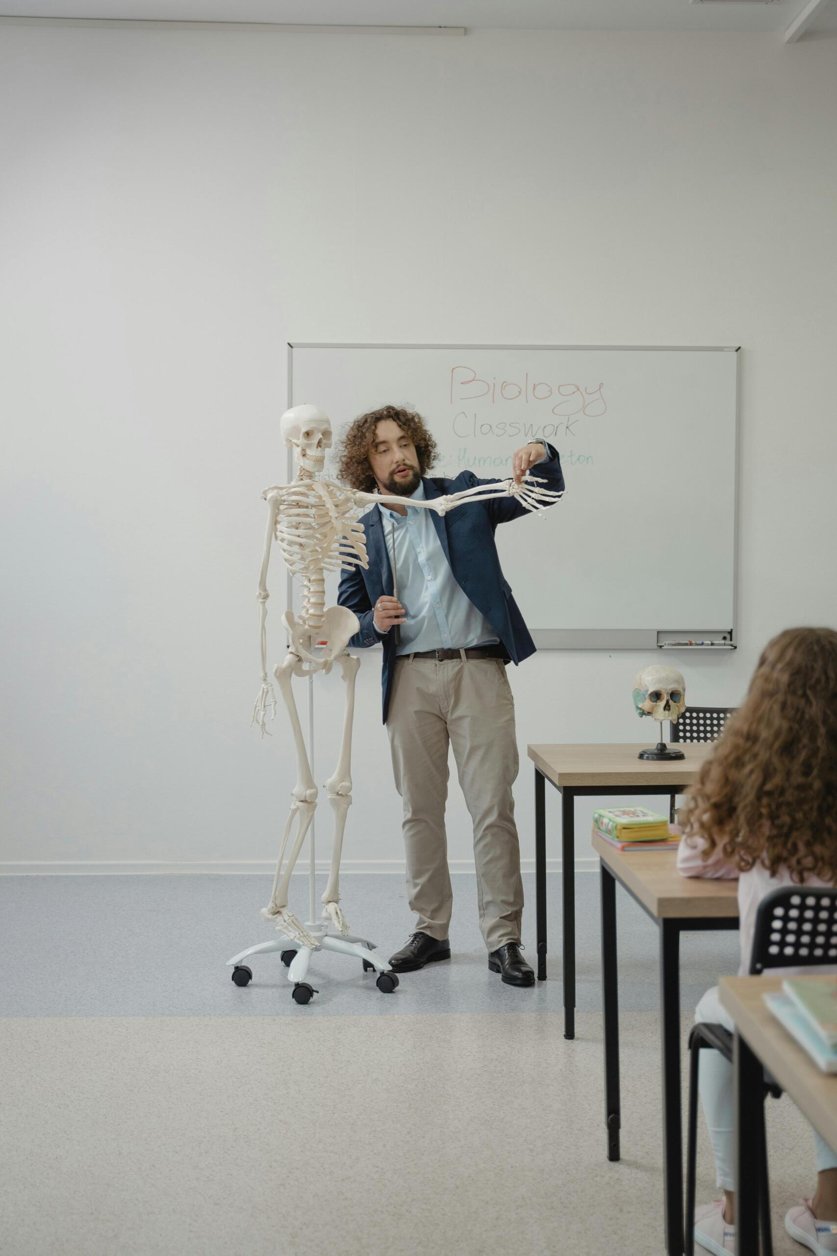 A teacher standing at the top of the class,  teaching biology