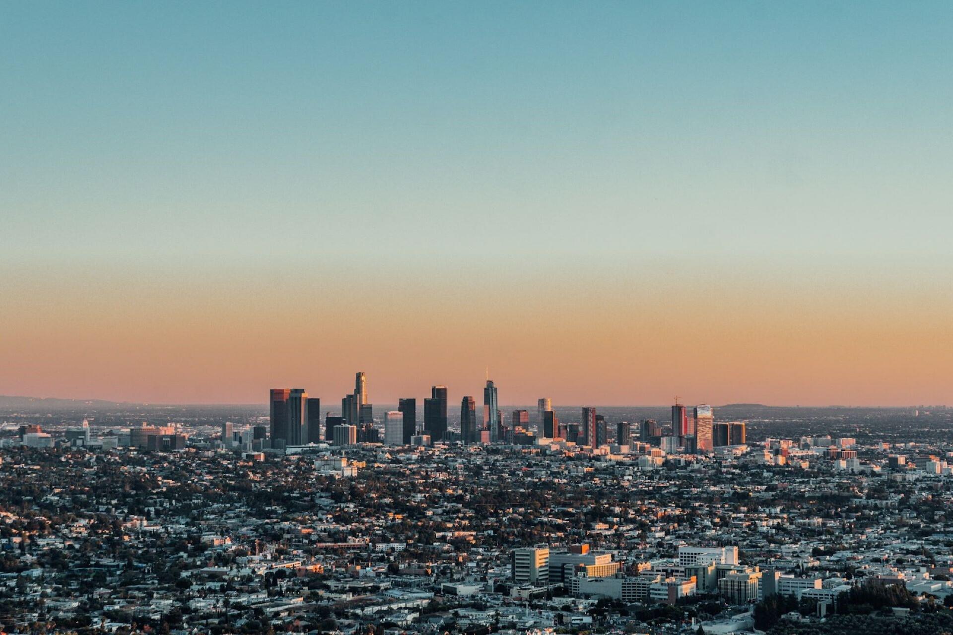 Skyline of Los Angeles with downtown buildings and city neighborhoods at sunset