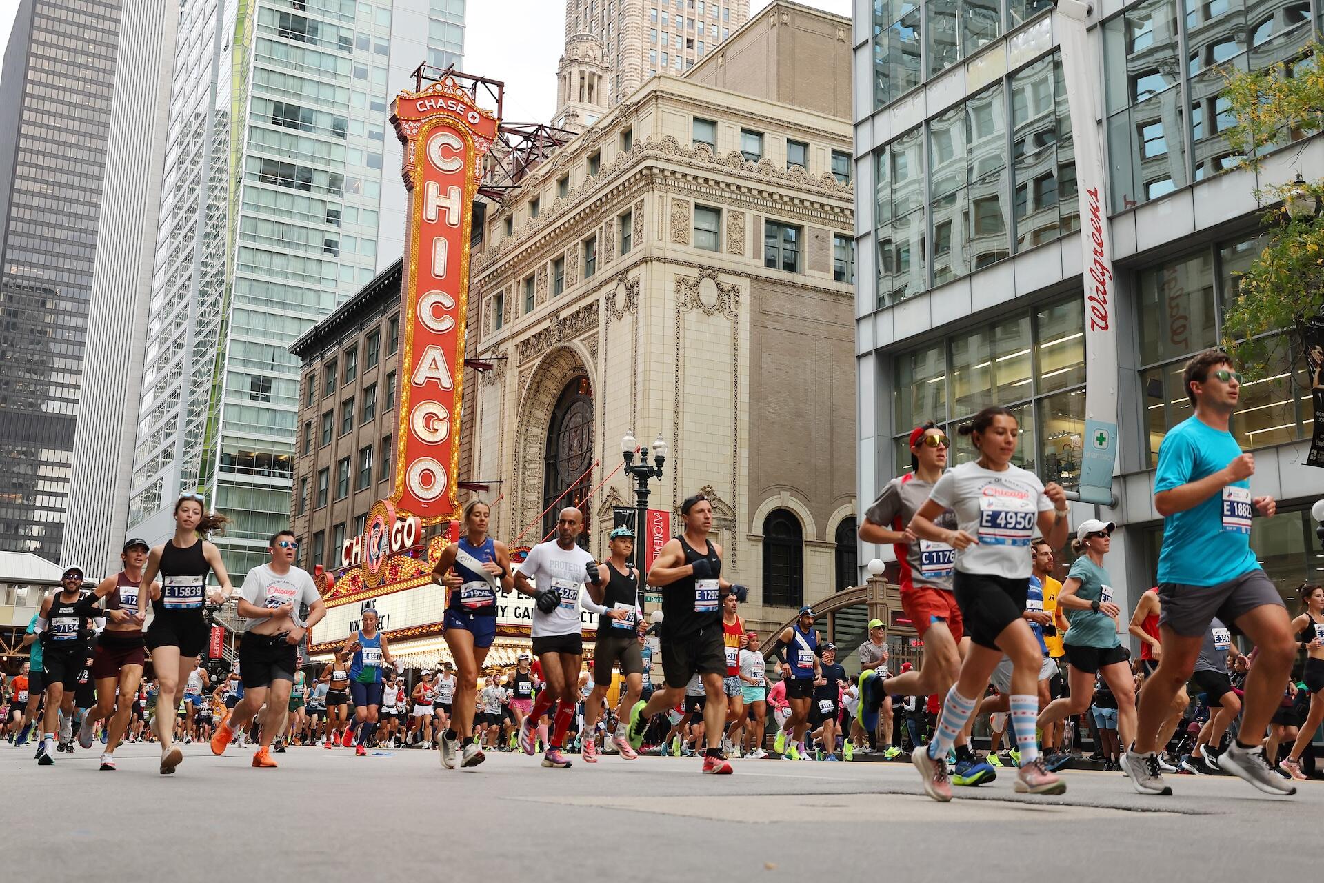 Runners going past the iconic Chicago Theater marquee signboard